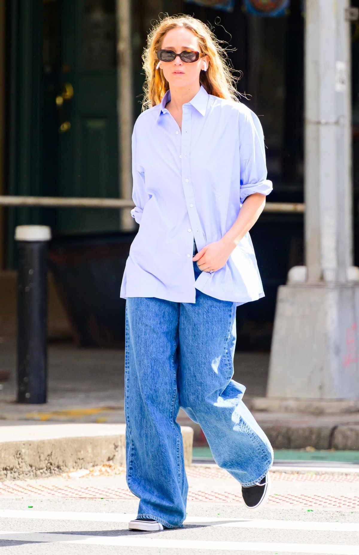 Jennifer Lawrence w baggy jeans, niebieskiej koszuli i czarnych Vansach.