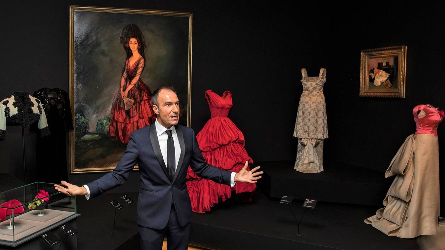 The Balenciaga exhibition curator, Eloy Martinez de la Pera, with the designers scarlet 1952 gown inspired by a 1921 portrait of the Duchess of Alba by Ignacio Zuloaga. Credit: @BORJALAMA