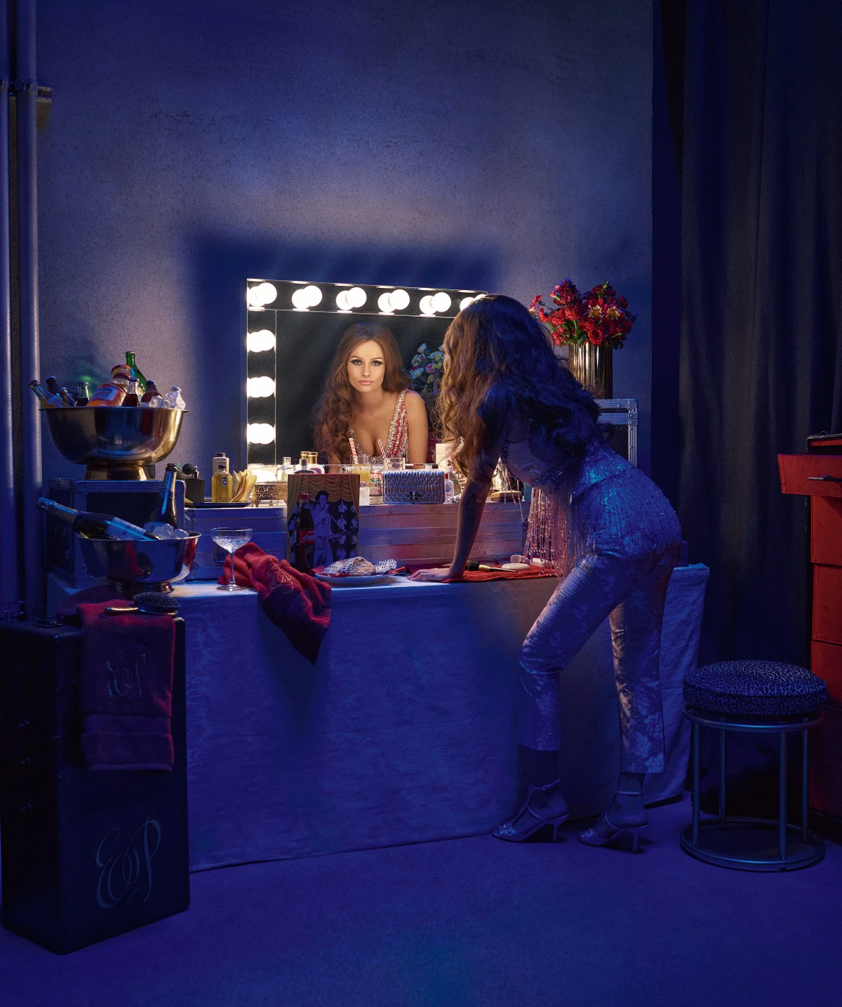 Olivia DeJonge jako Priscilla Presley połyskującej tunice od Miu Miu za kulisami filmu. Zdjęcie zrobiono na planie repliki showroomu International Hotel.