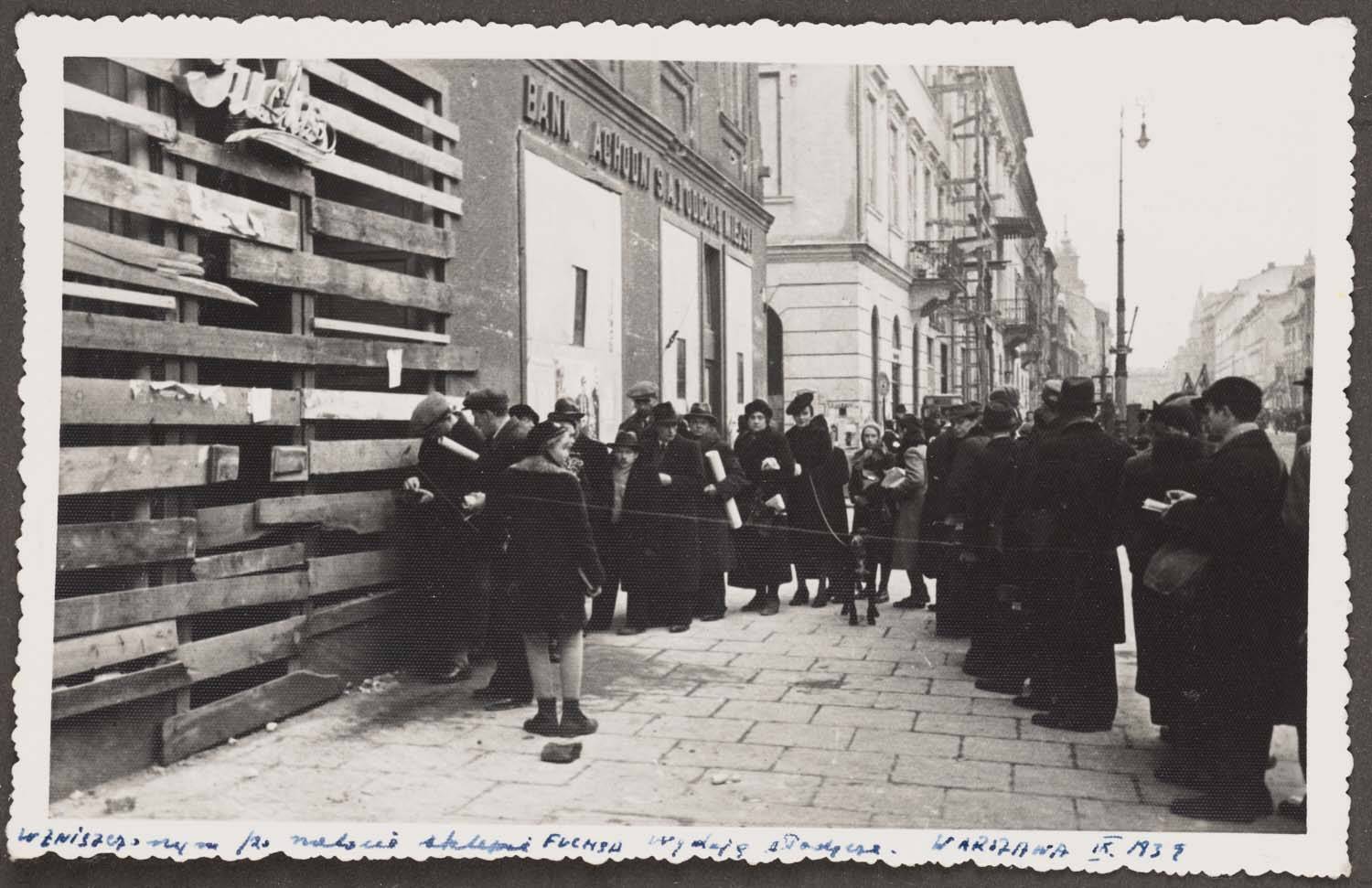Kolejka przed sklepem ze słodyczami firmy Franciszek Fuchs i Synowie przy Nowym Świecie 51.