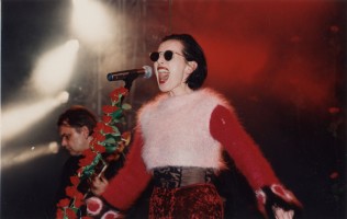 Kora podczas koncertu zespołu Maanam w warszawskiej Stodole. W tle basista Krzysztof Olesiński. 1994, Fot. Andrzej Georgiew, © M. B. F. Georgiew / FAF