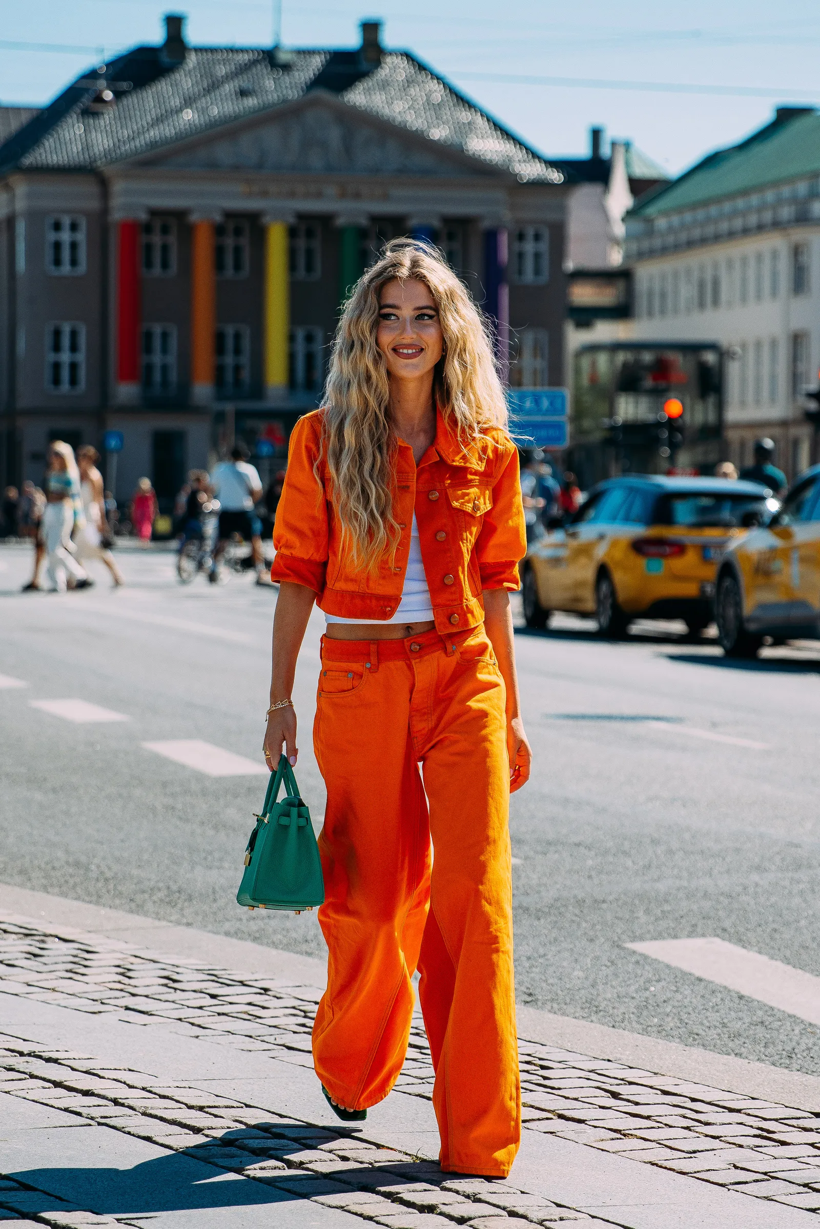 Pomarańczowy, jeansowy set przyciąga gorące promienie słońca w Kopenhadze. It-girls zestawiają go z białym tank topem i zieloną torebką Birkin od Hermèsa.