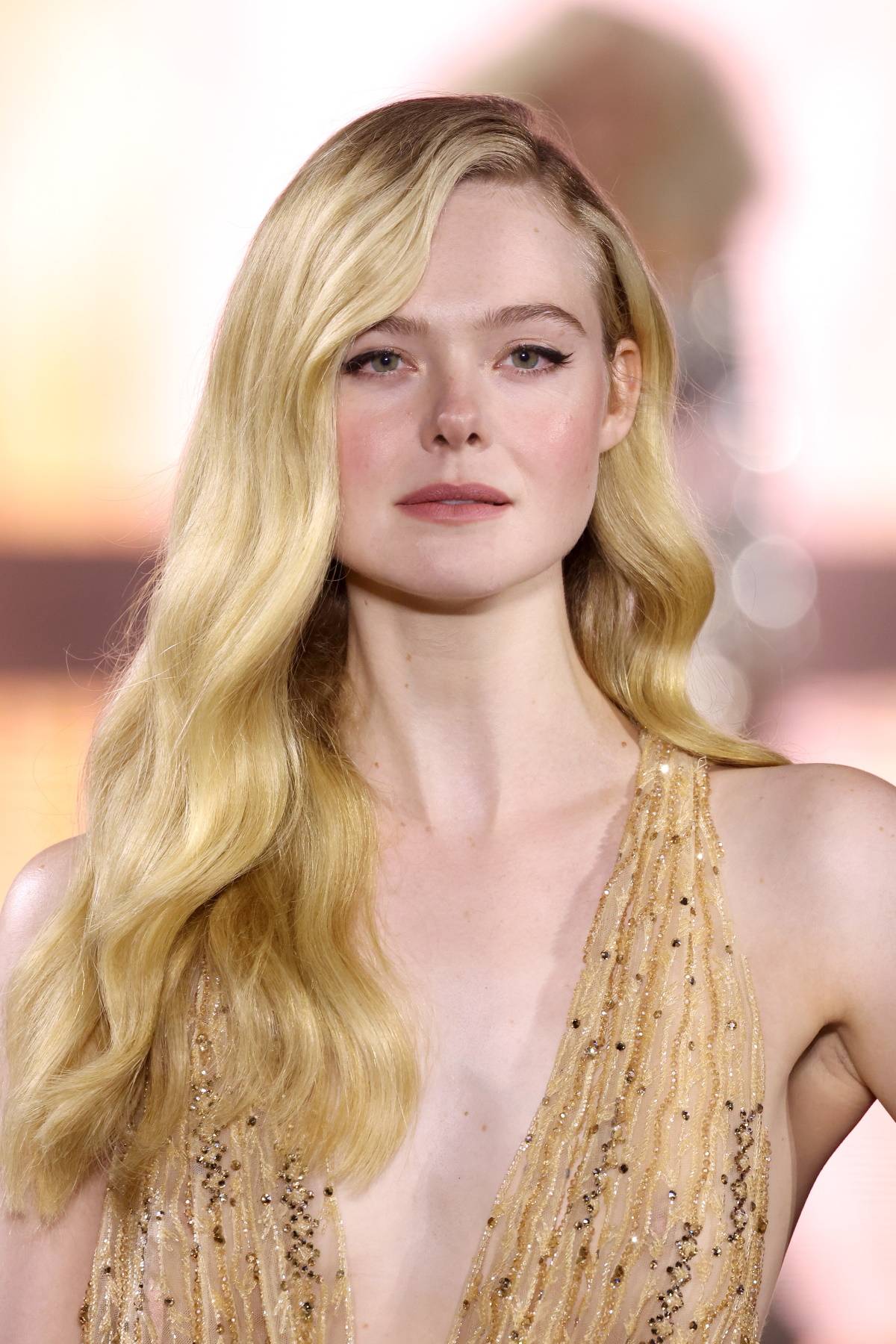 Elle Fanning w prostych jeansach, skarpetkach, mokasynach.