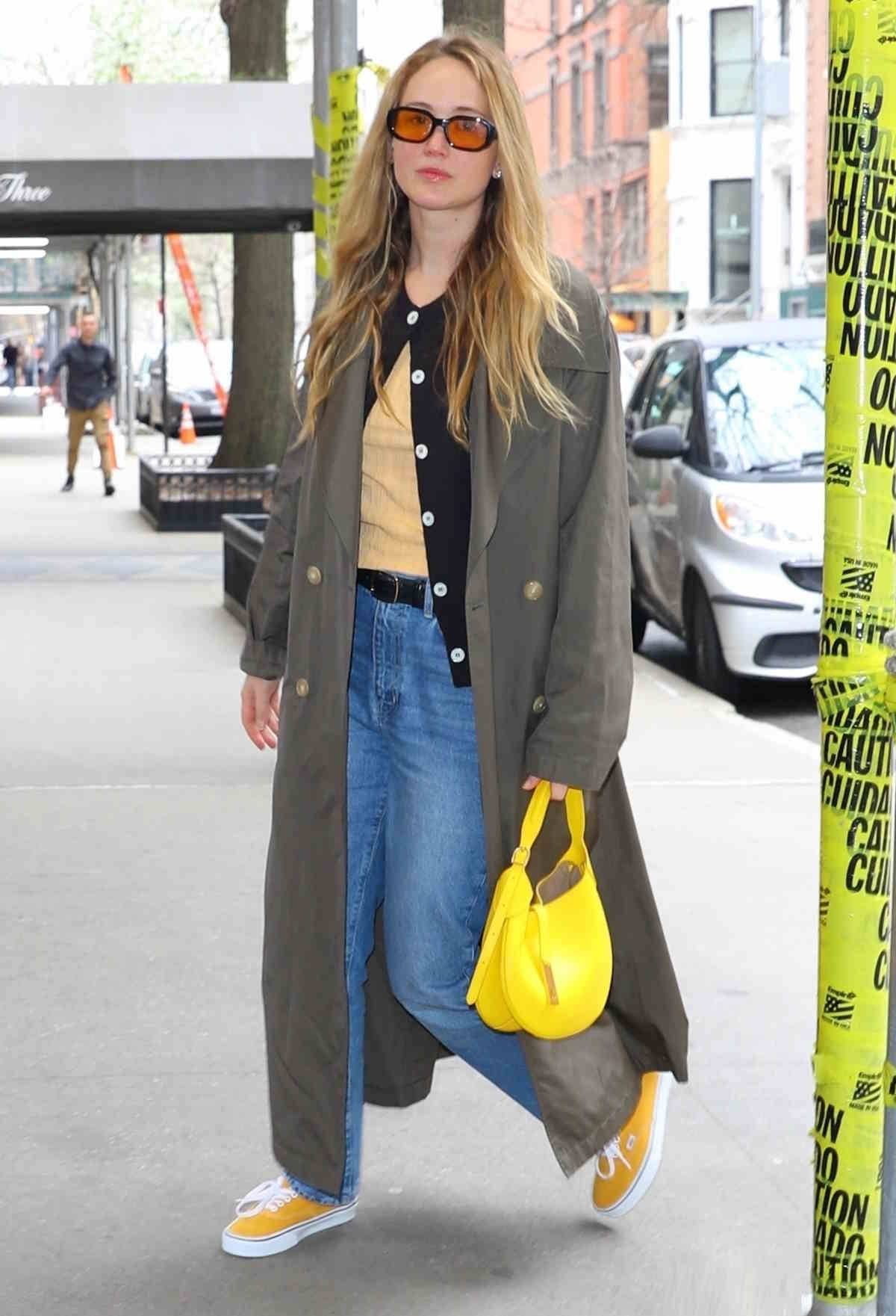 Jennifer Lawrence w kolorowych vansach, jeansach i z kanarkową torebką.