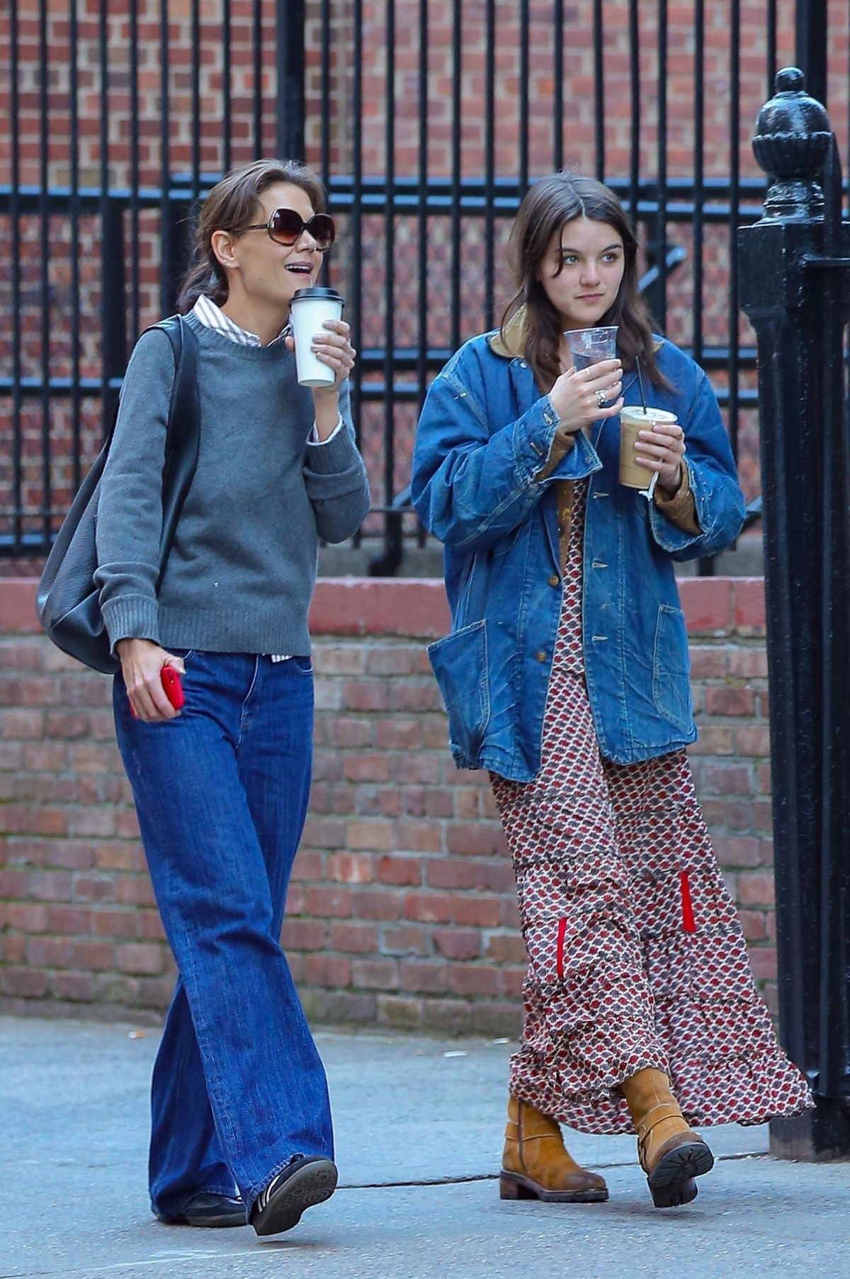 Katie Holmes z córką Suri Cruise. Katie Holmes w jeansach, szarym swetrze i czarnych sneakersach samba marki adidas. Suri Cruise w jeansowej kurtce, sukience i brązowych zamszowych kozakach.