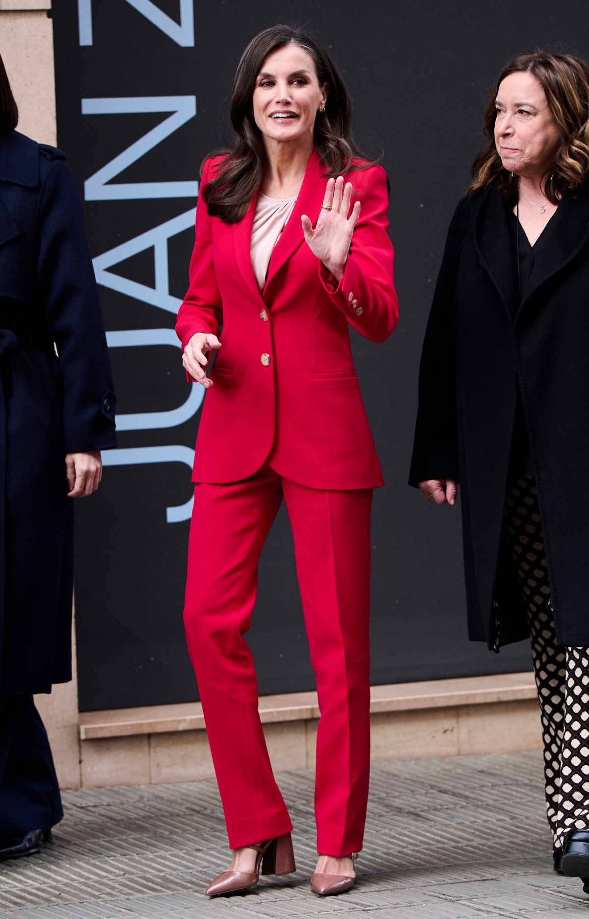 Królowa Letycja do dopasowanego modelu garnituru w czerwonym kolorze wybiera buty w nieoczywistym odcieniu nude.