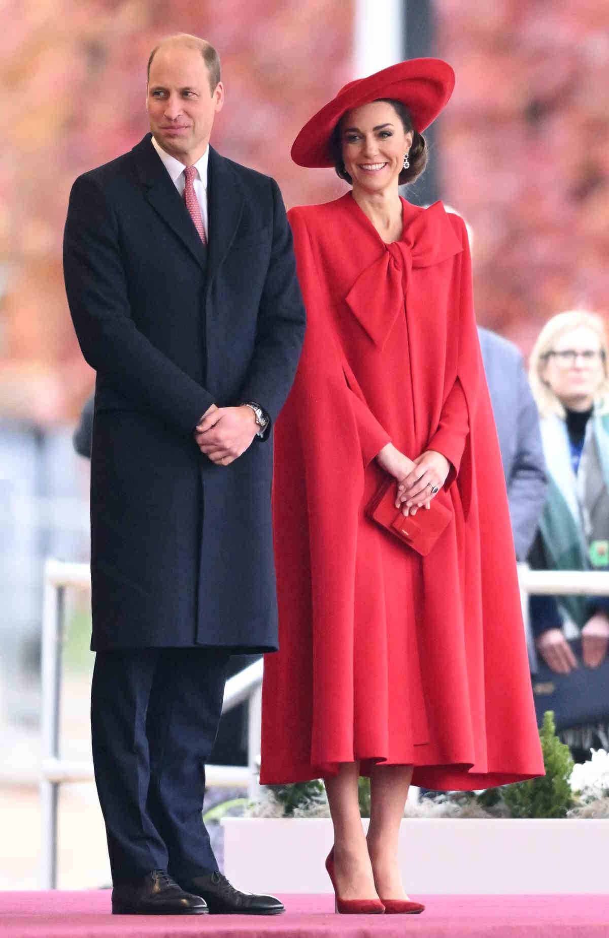 Kate Middleton w modnej czerwieni. Księżna Walii tego dnia zachwyciła także czerwoną suknią projektu Catherine Walker z efektowną kokardą, którą uzupełniła eleganckim kapeluszem i peleryną.