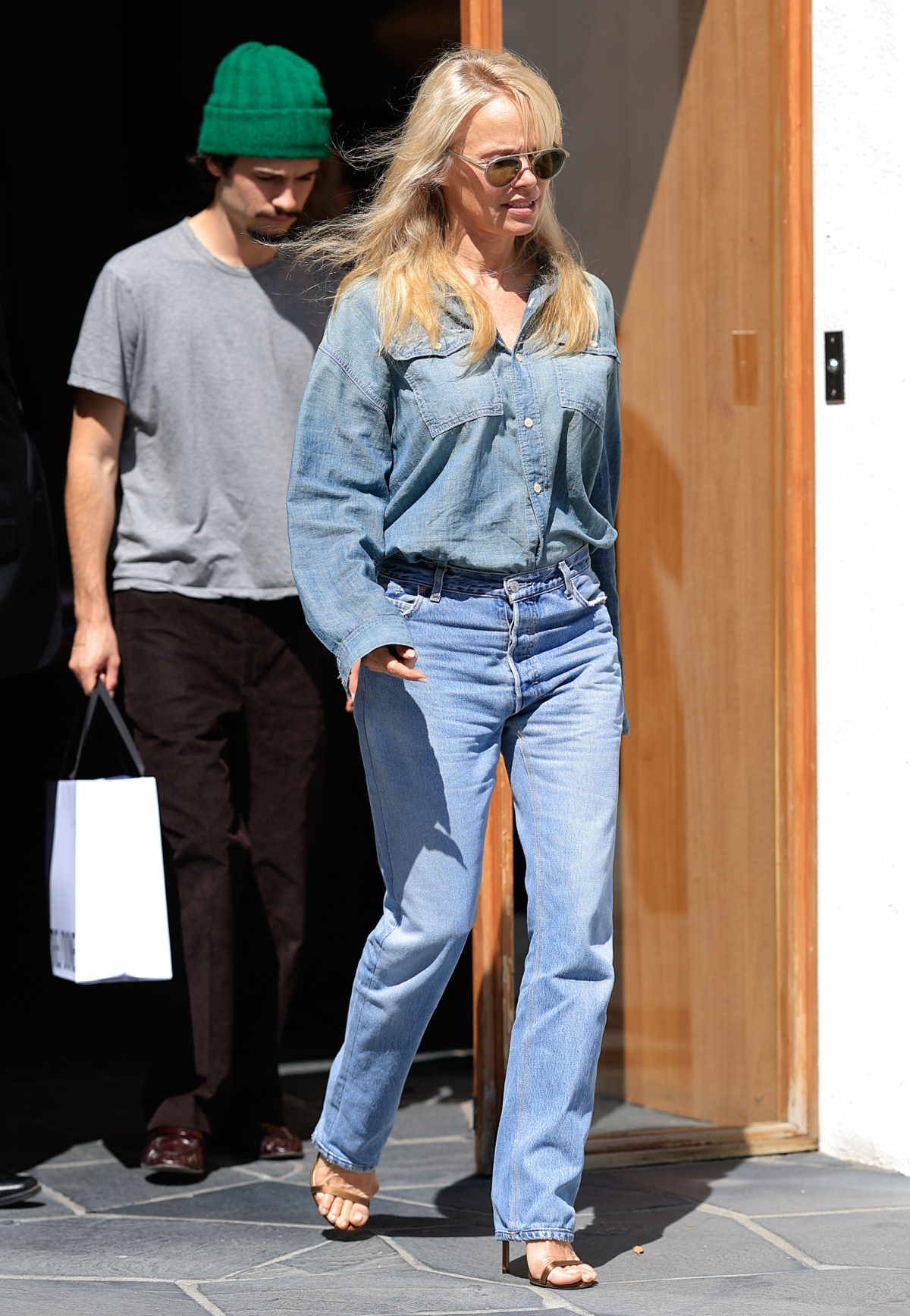 Pamela Anderson w jeansowym total looku. Jeansową koszulę i proste jeansy zestawiła ze złotymi klapkami na szpilce.