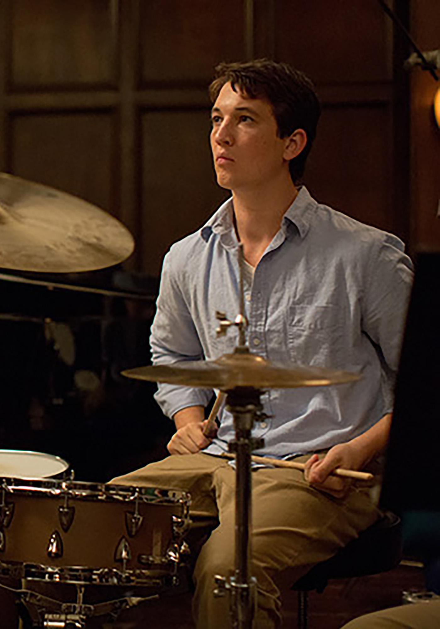 Kadr z filmu „Whiplash”, reż. Damien Chazelle, przedstawia młodego perkusistę w trakcie intensywnej gry.