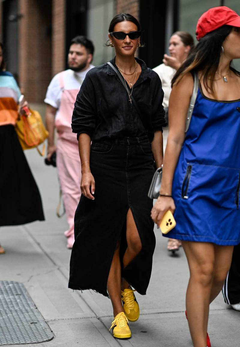 Street style nie ma wątpliwości – żółte sneakersy są nie tylko wszechstronne, lecz również niezwykle atrakcyjne. Spójrz tylko na stylizacje z casualowymi spódnicami midi (Fot. Getty Images)