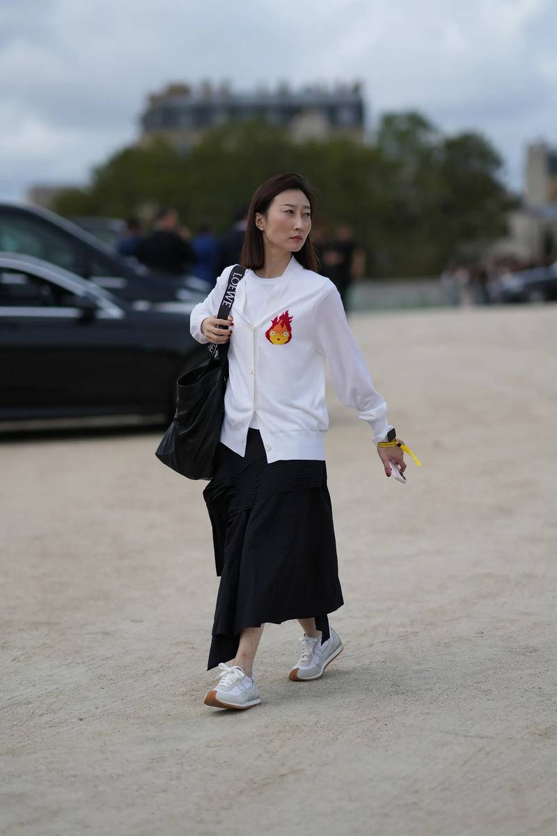 Białe sneakersy na grubej podeszwie do asymetrycznej spódnicy to doskonała propozycja dla miłośniczek minimalizmu (Fot. Getty Images)