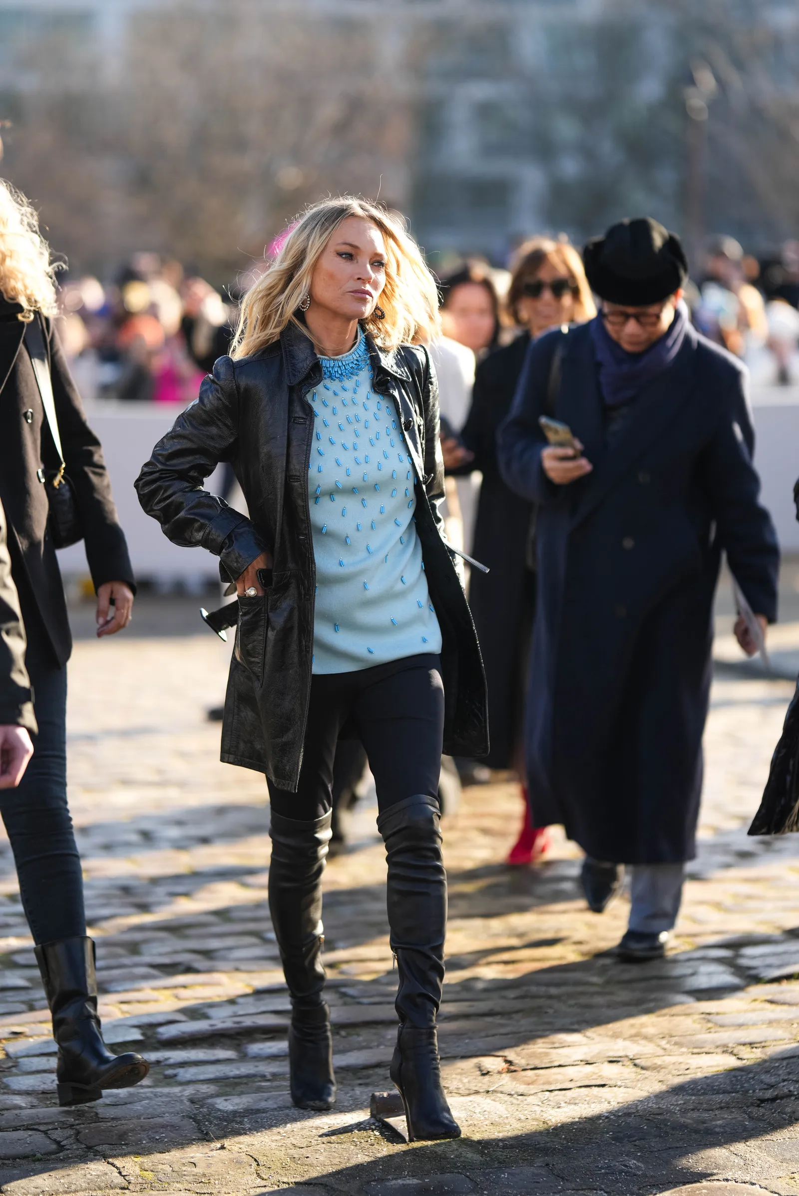 Kate Moss do czarnych wąskich spodni dobrała czarną skórzaną kurtkę, niebieski top i czarne kozaki za kolano (Fot. Edward Berthelot/Getty Images)