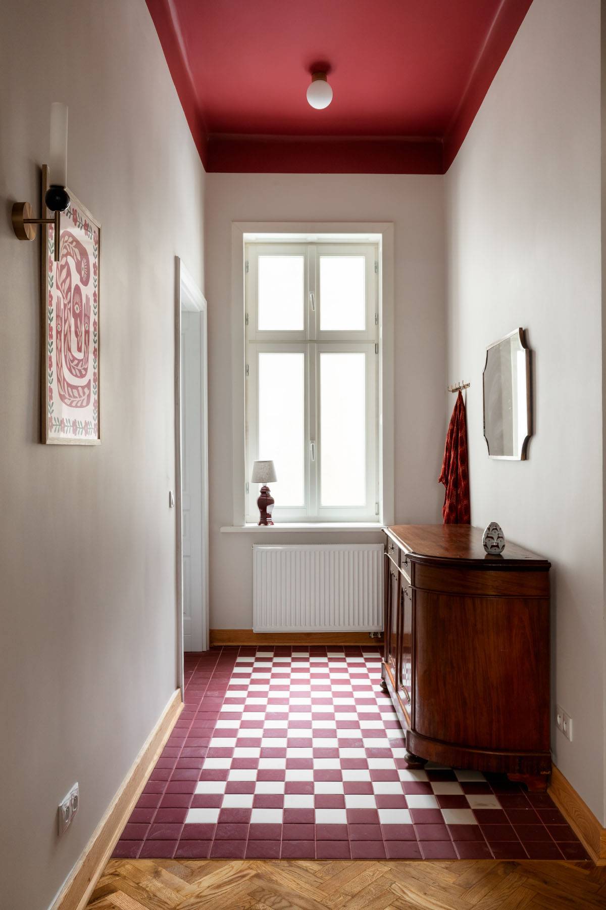 Podłogowe biało-bordowe włoskie kafle w przedpokoju układem nawiązują do tych zdobiących klatkę schodową (Fot. Patryk Polewany)