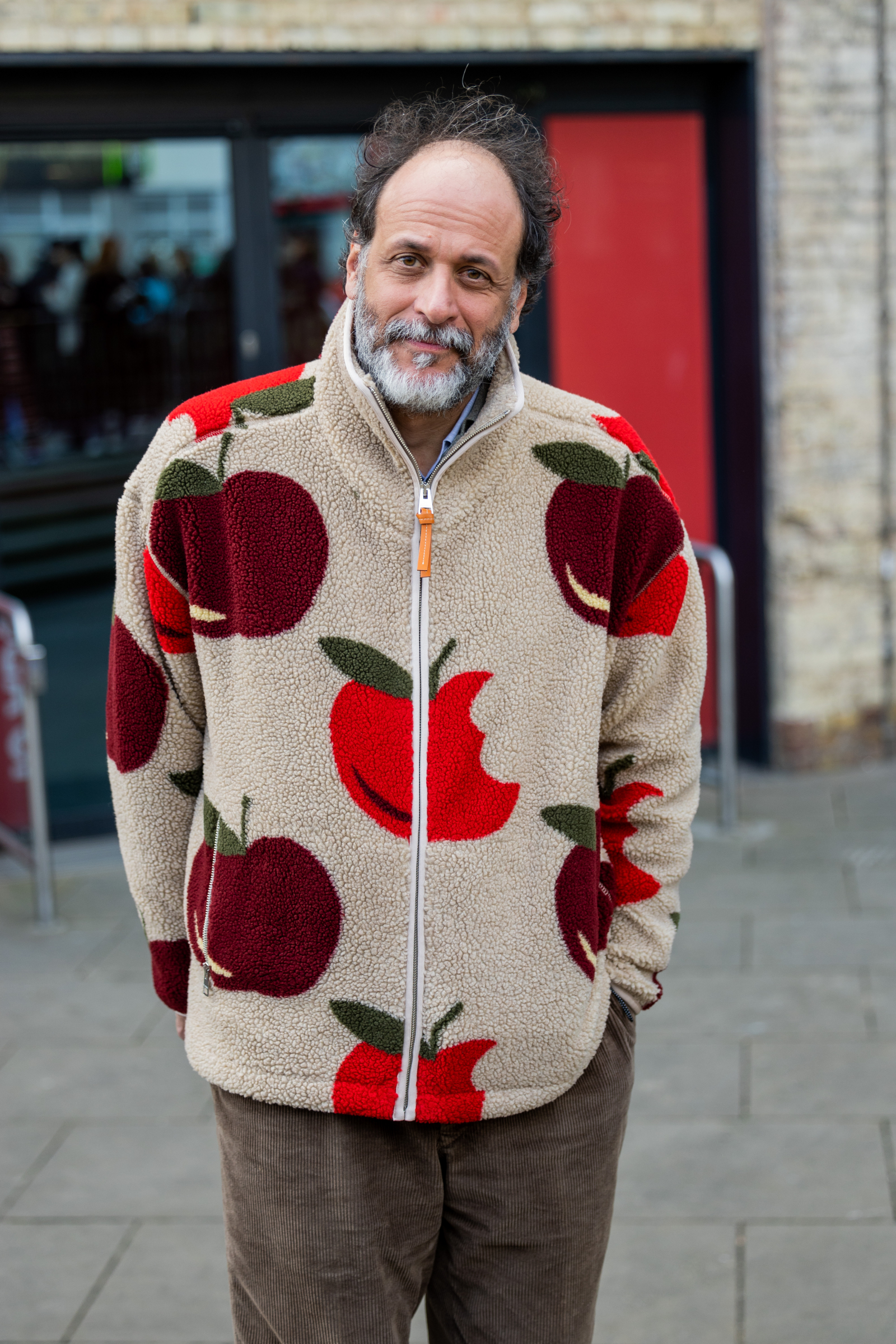 Luca Guadagnino w zapinanym na suwak beżowym polarze w jabłka od JW Andersona (Fot. Christian Vierig/Getty Images)