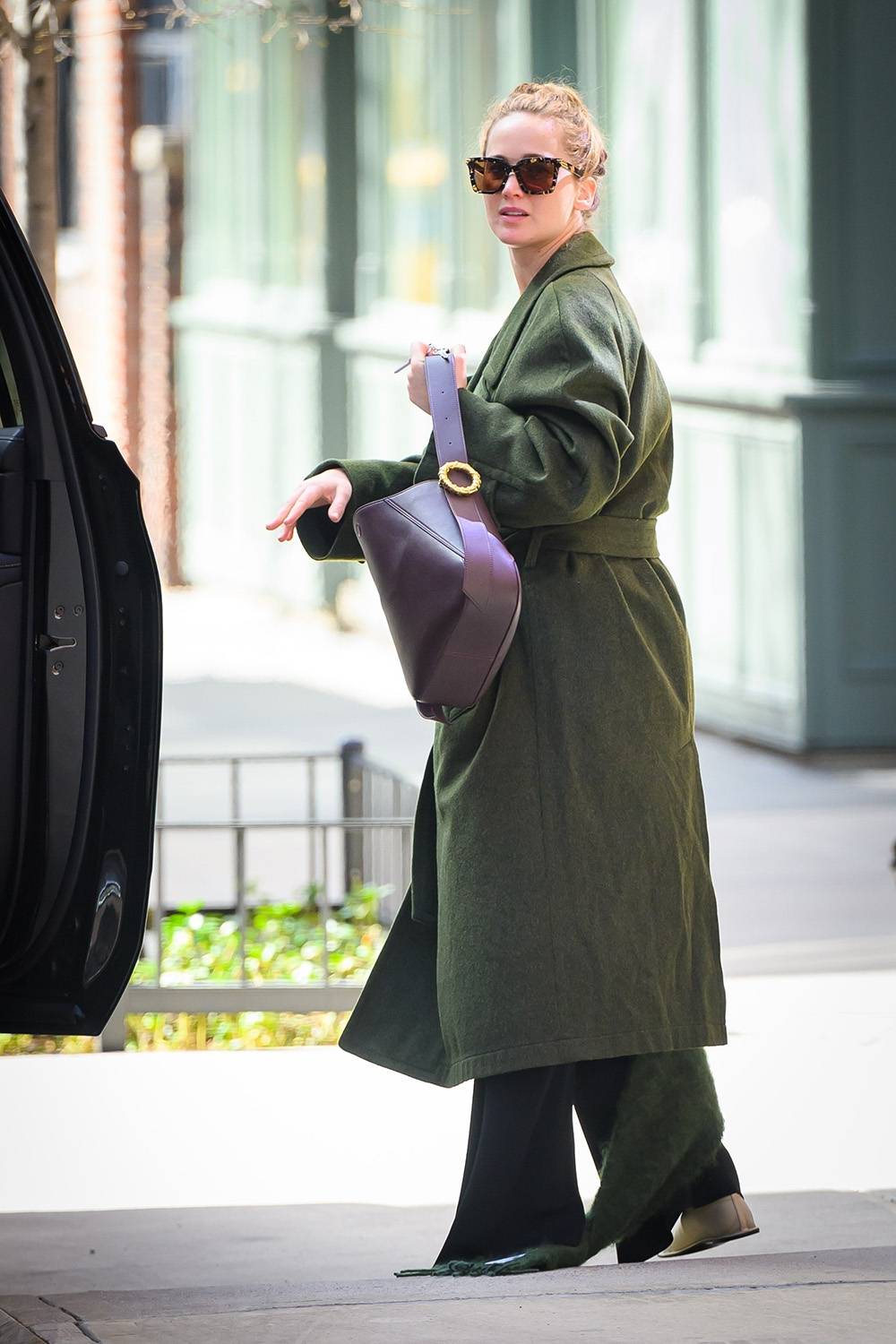 Casualowy wiosenny look Jennifer Lawrence zawiera ekstrawaganckie buty na płaskiej podeszwie od The Row. To ulubiona marka gwiazdy, jej logo ma też trencz użyty w stylizacji. Fot. East News
