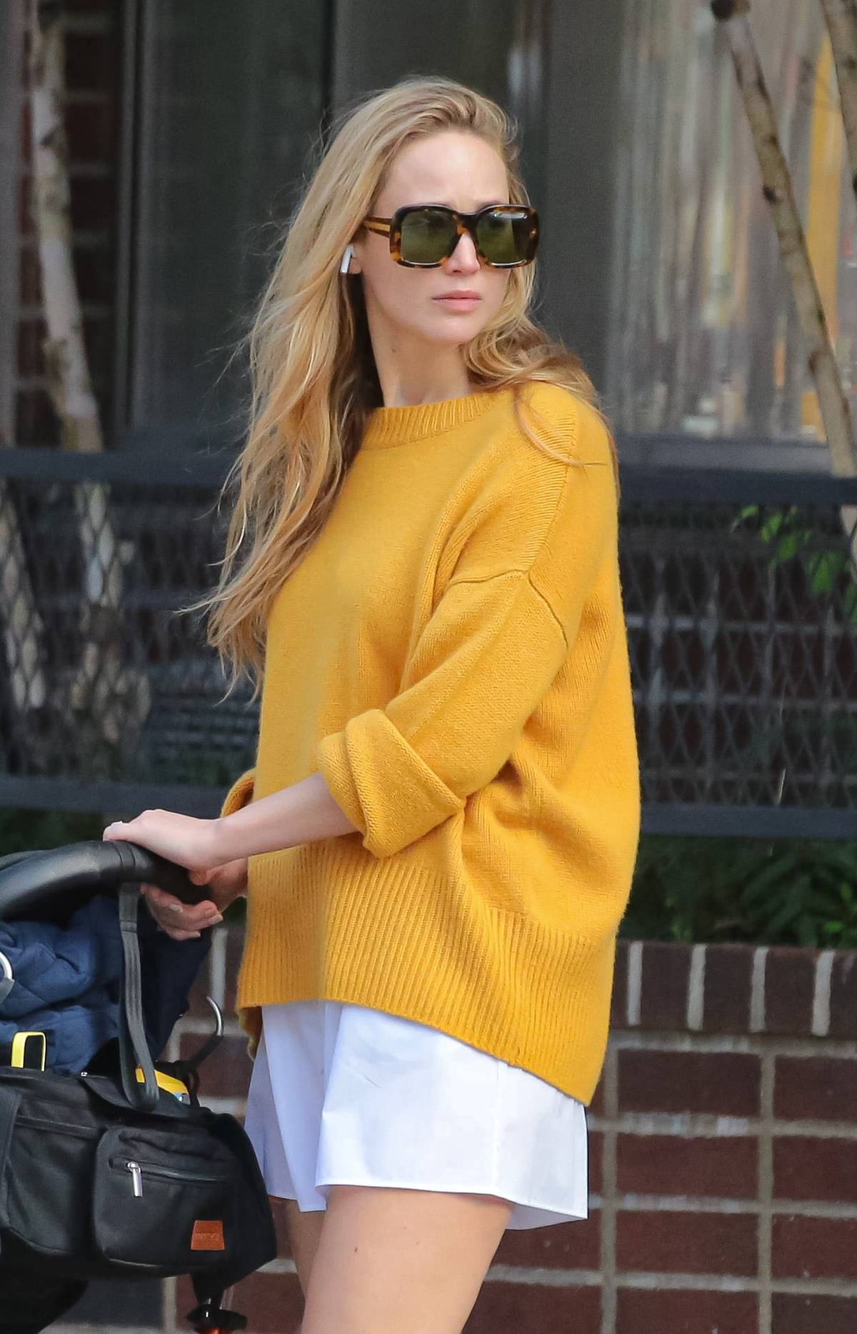 Jennifer Lawrence w jesiennym wydaniu trendu no pants w swetrze i birkenstockach z skarpetkami.