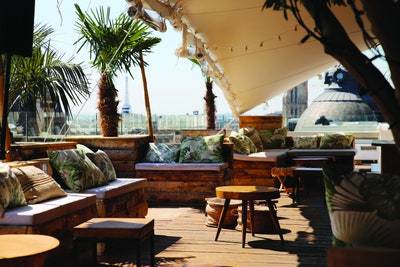 The rooftop terrace at Le BHV Marais overlooks Paris, with the Eiffel Tower in the background
© Sous les Fraises
[Image may contain: Wood, Plywood, Hardwood, Patio, Plant, Tree, Palm Tree, and Arecaceae]