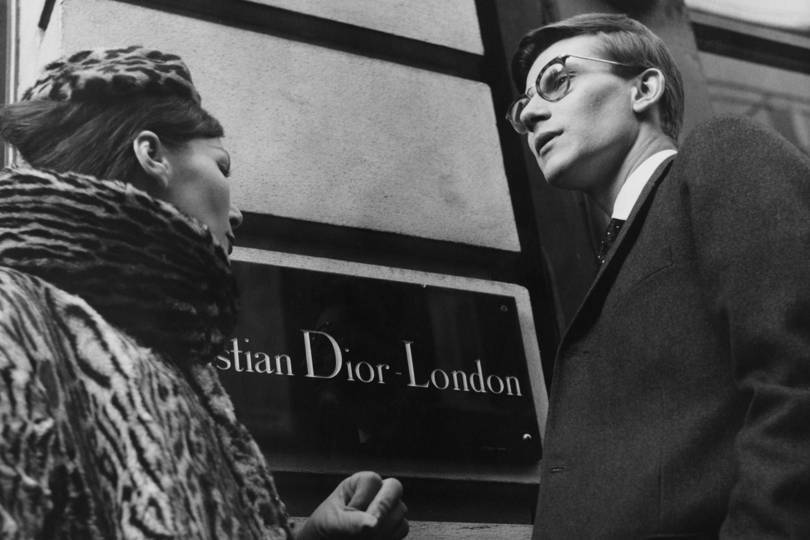 Yves Saint Laurent and a house model in front of Christian Dior London, 11th November 1958. Credit: POPPERFOTO / GETTY IMAGES