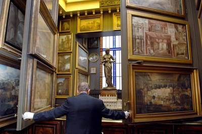A warden at the Sir John Soane Museum opens secret wall panels that reveal paintings by Hogarth behind
© Bloomberg / Getty