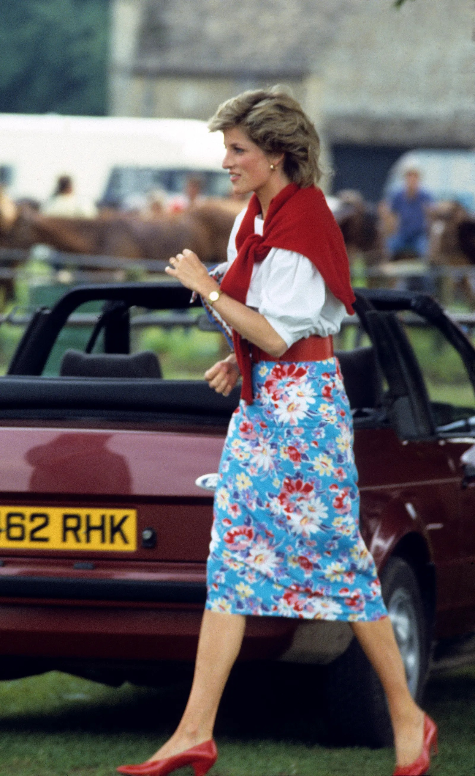 Podczas meczu polo w czerwcu 1985 roku Diana pokazała się w kwiecistej spódnicy midi połączonej z białą bluzką, czerwonymi czółenkami i czerwonym kardiganem przewiązanym na ramionach. (Fot. Anwar Hussein/Getty Images)