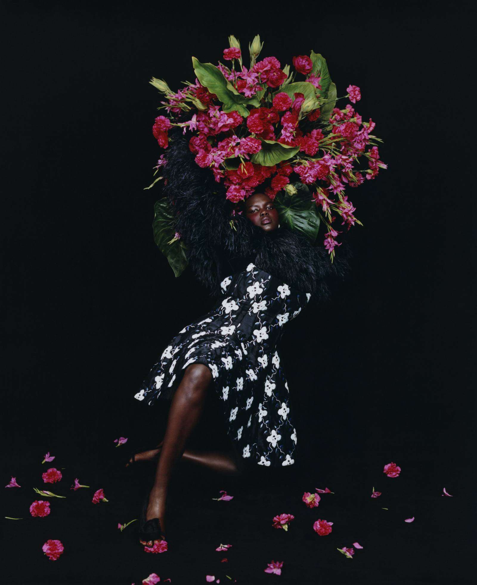Modelka ubrana w czarno-białą sukienkę trzyma bukiet kwiatów
