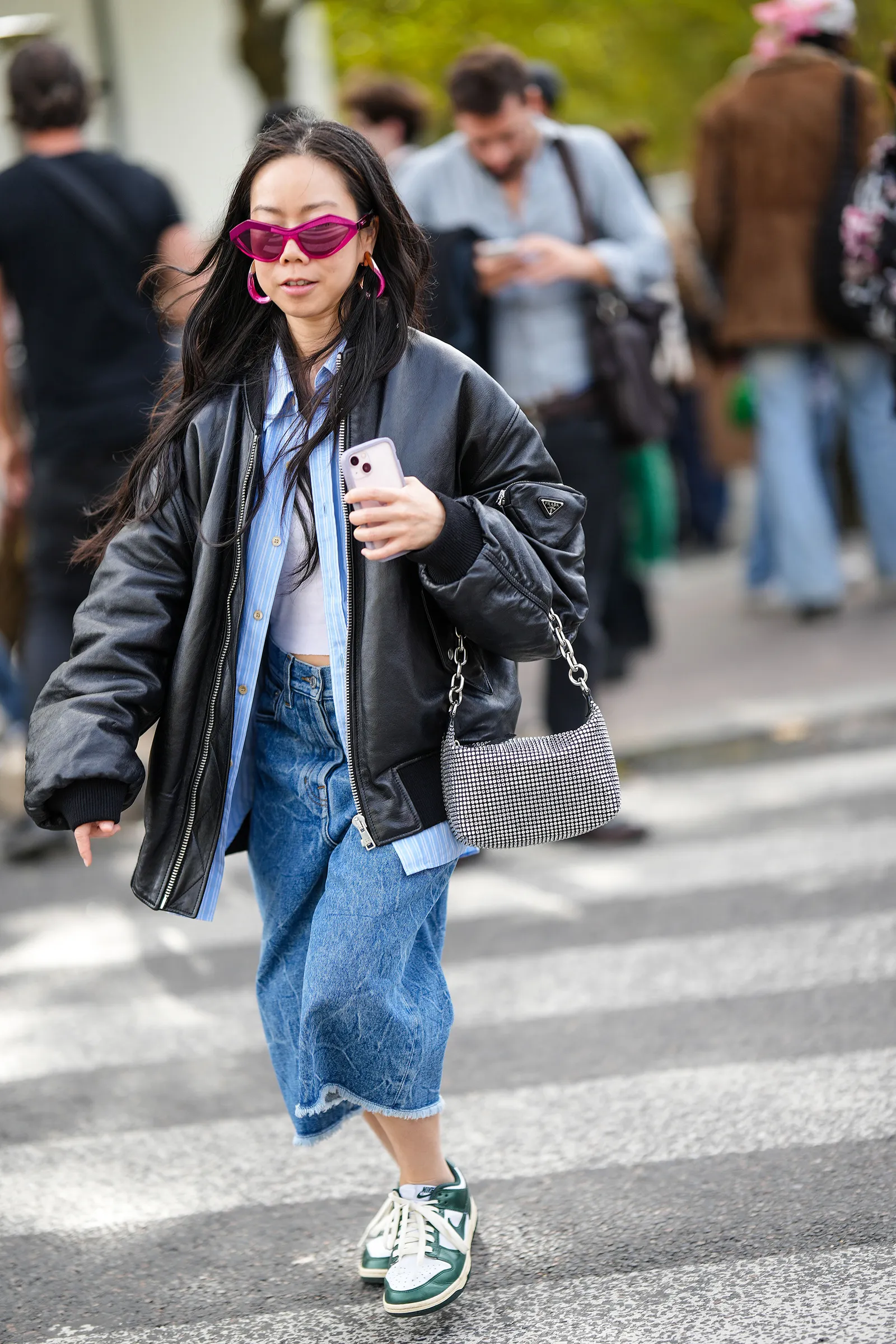 Skórzana kurtka idealnie pasuje do jeansowej spódnicy midi i sneakersów / Fot. Getty Images
