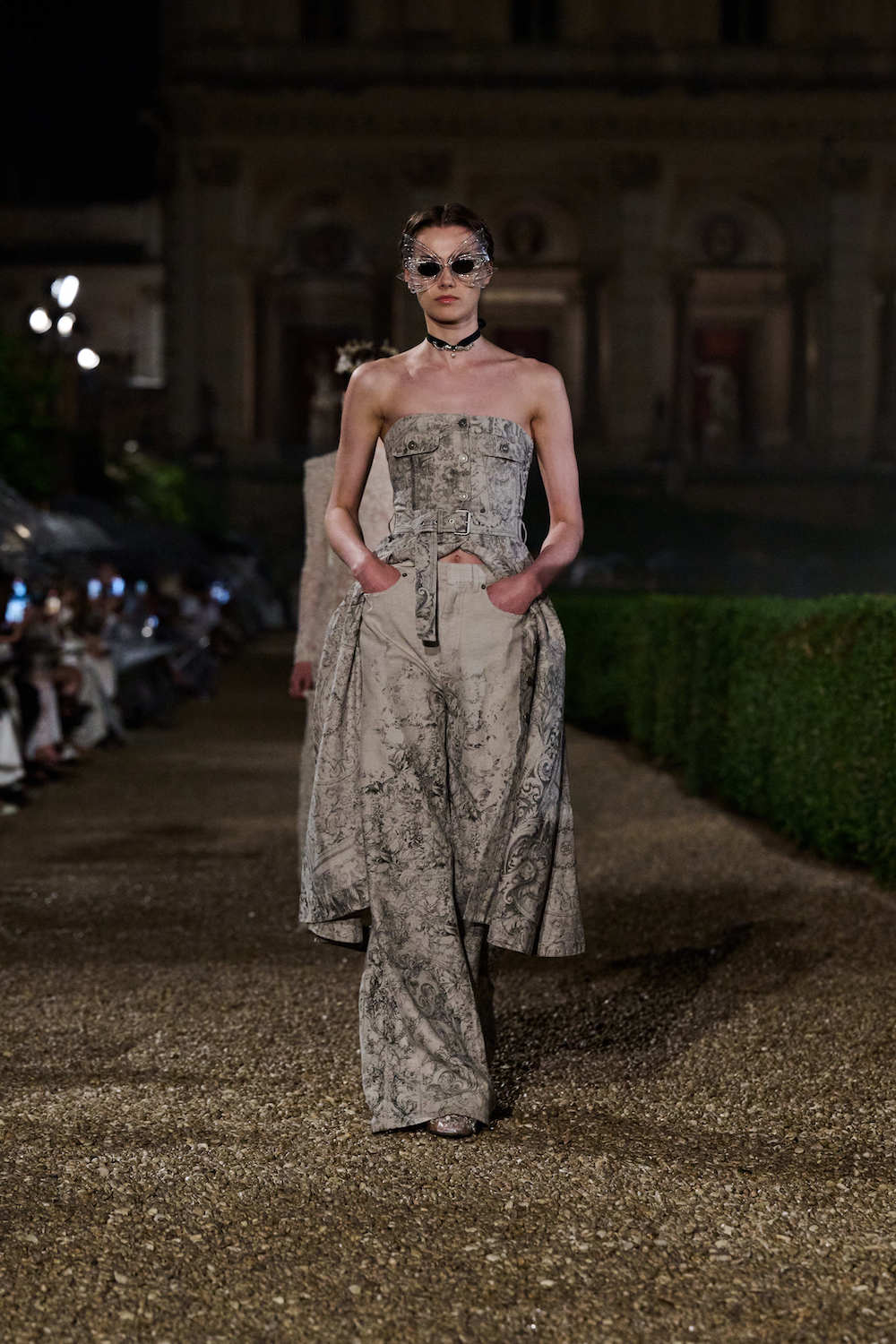 Modelka w eleganckiej stylizacji prezentuje koronkowe sukienki na lato i ślub na wybiegu w nocy.