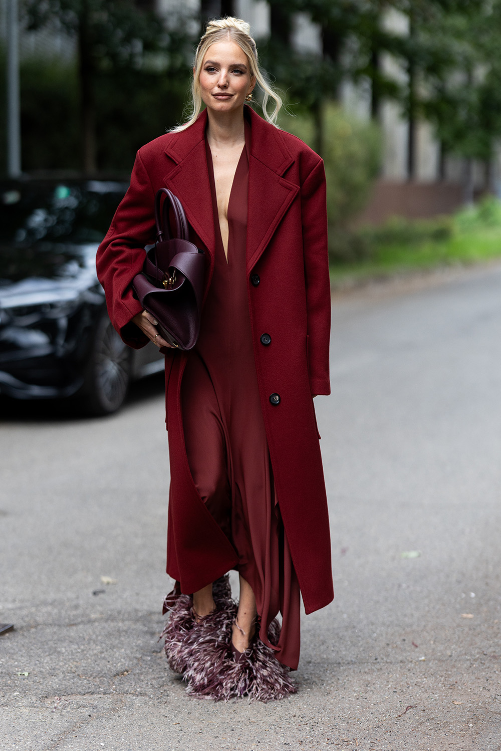 Leonie Hanne na pokazie Ferragamo wybiera bordowy, elegancki płaszcz, który łączy ze złotem. Fot. Valentina Frugiuele / Getty Images