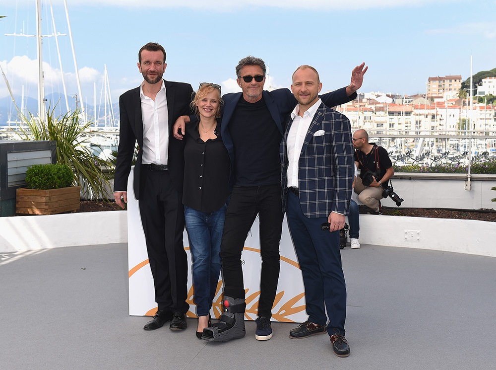 Paweł Pawlikowski pozując z ekipą, na tle portu, podczas wydarzenia w Cannes.