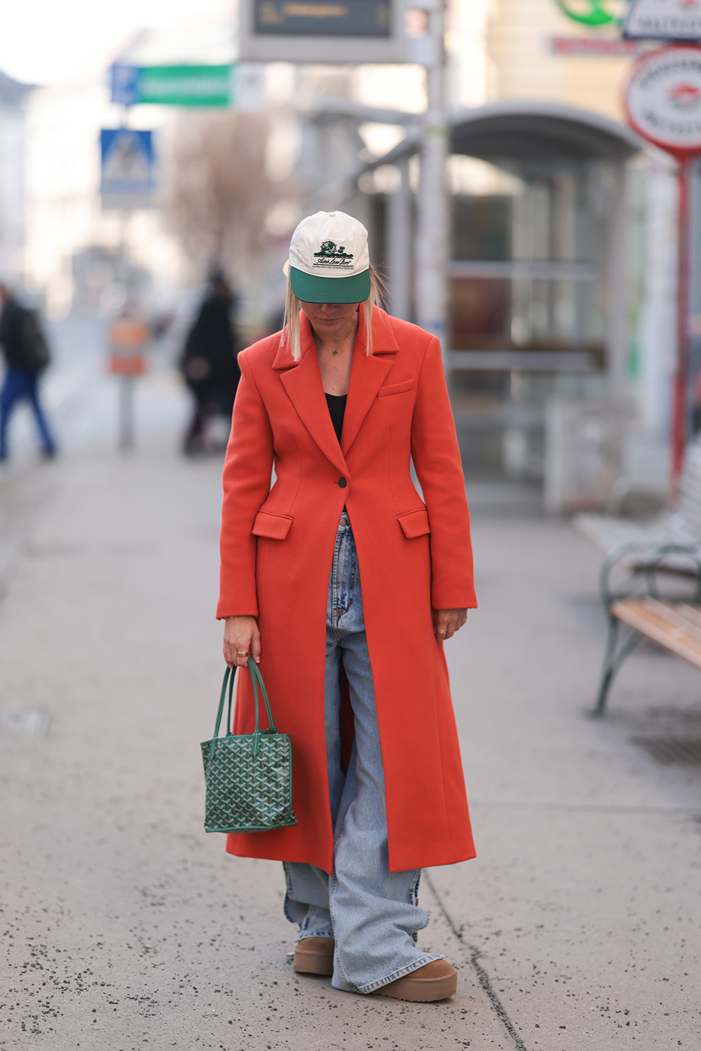 Karin Teigl na spacer po Berlinie wybiera brązowe buty Ugg i niebieskie jeansy z szeroką nogawką, ale pierwsze skrzypce gra paprykowy płaszcz. Fot. Jeremy Moeller/Getty Images
