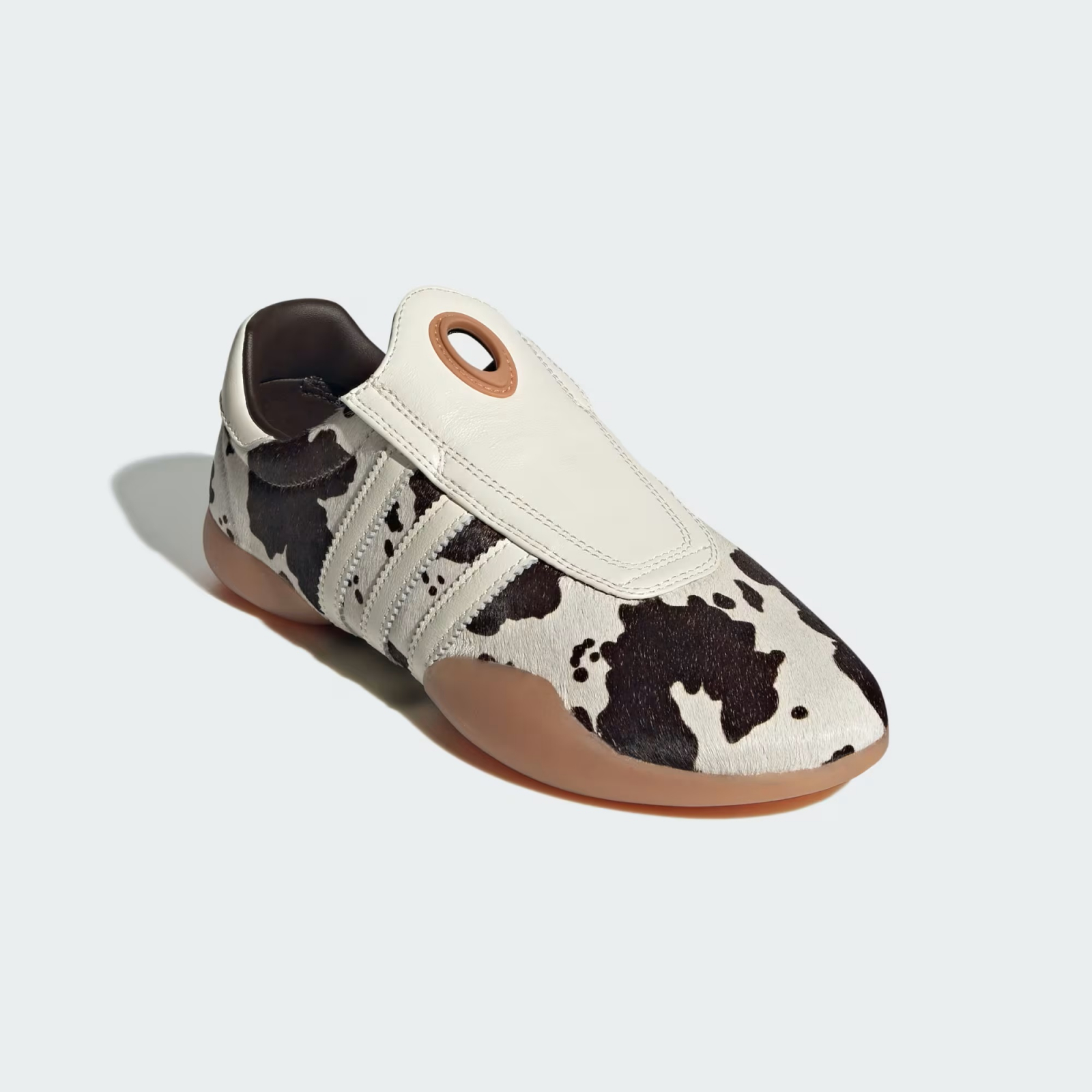 Sneakersy w krowie łaty marki Adidas, model taekwondo z charakterystycznym zapięciem.