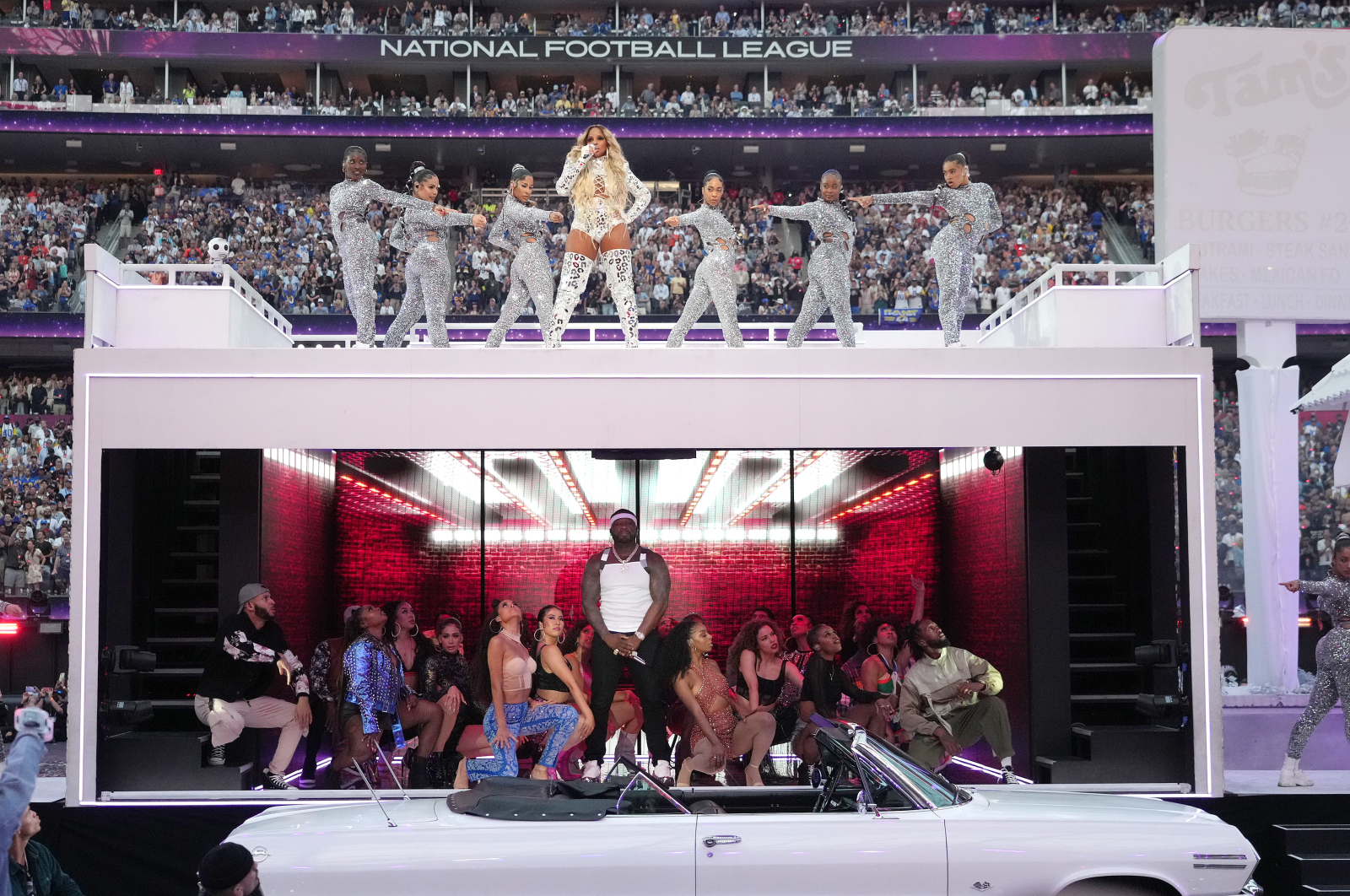 Mary J. Blige i 50 Cent występują na scenie podczas Super Bowl, otoczeni tancerzami i publicznością.