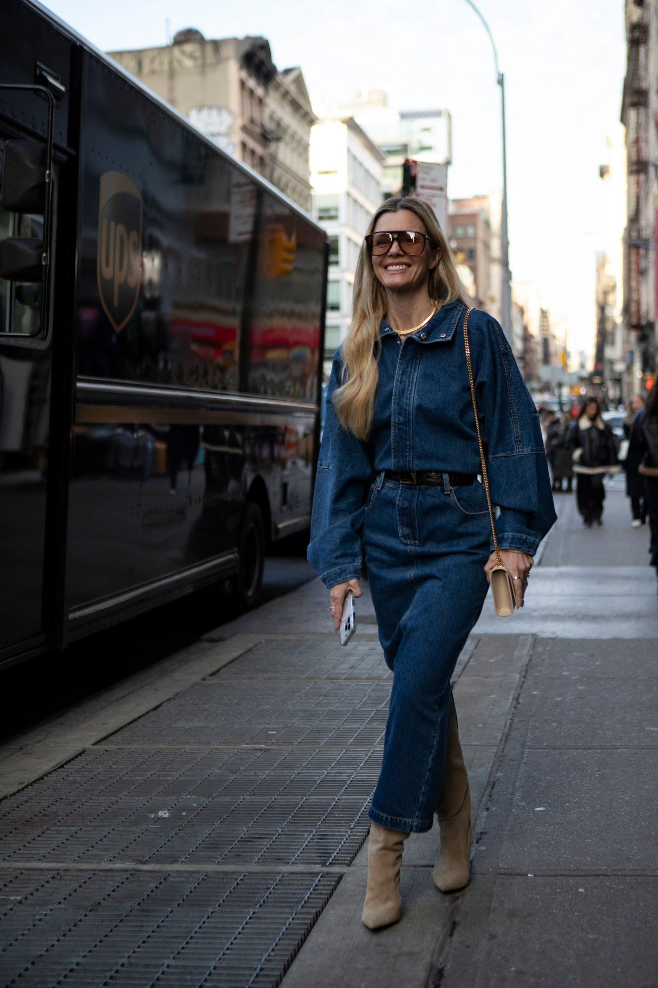 Street style nie pozostawia wątpliwości: jeansowe komplety najlepiej prezentują się w towarzystwie wysokich brązowych kozaków (Fot. Spotlight. Launchmetrics )