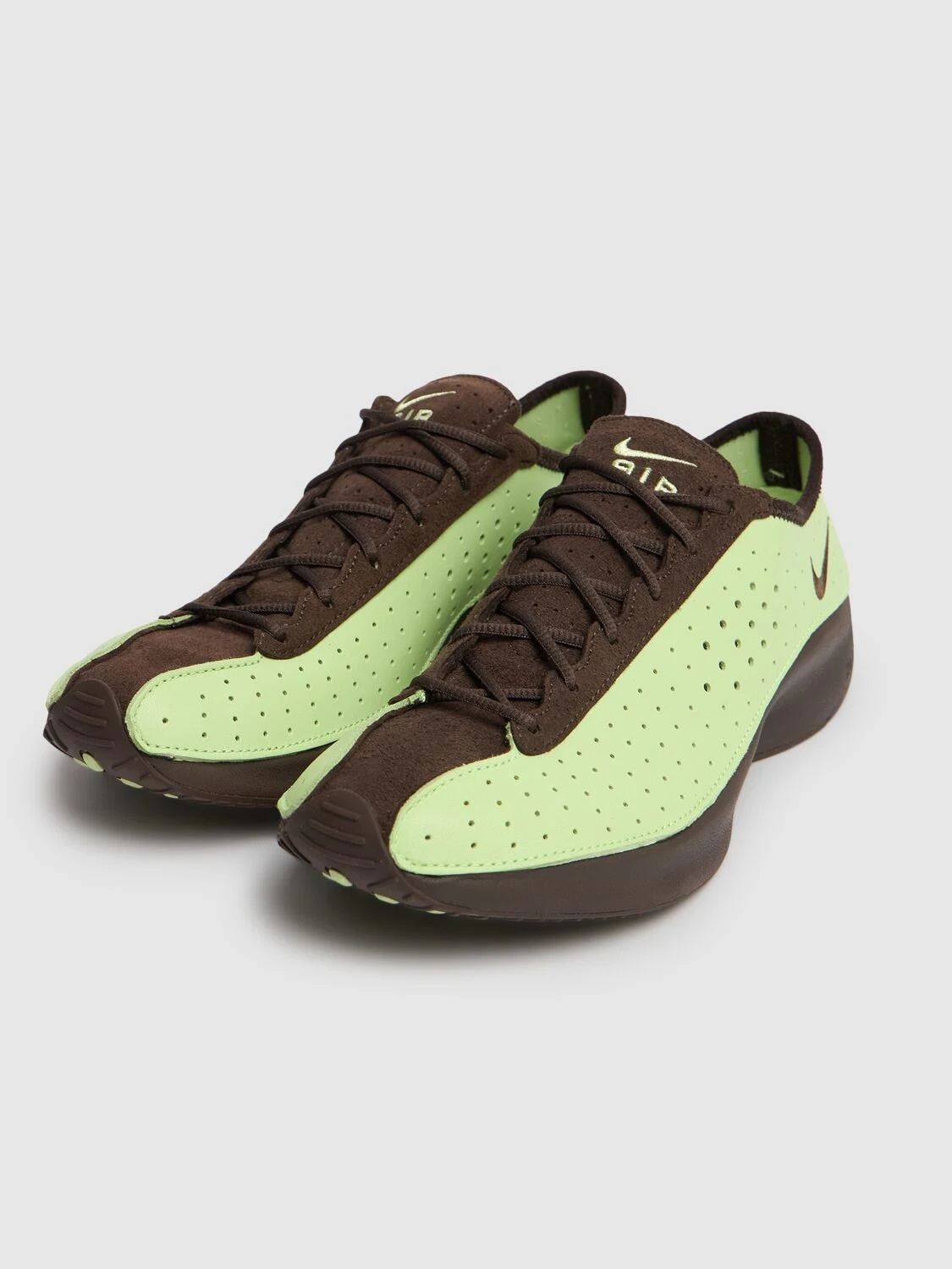 Zielone sneakersy z brązowymi akcentami, z perforowaną cholewką i podeszwa w ciemnym kolorze.