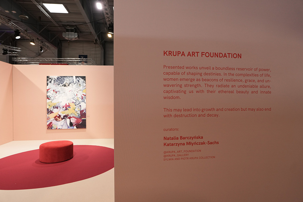 Ekspozycja Krupa Art Foundation z pracami ukazującymi siłę kobiet. Na różowym tle widać obraz i okrągłą platformę.