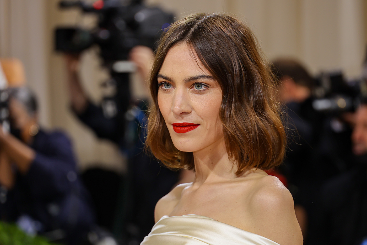 Alexa Chung w lekko falowanym bobie i w szampańskiej sukience bez ramiączek.