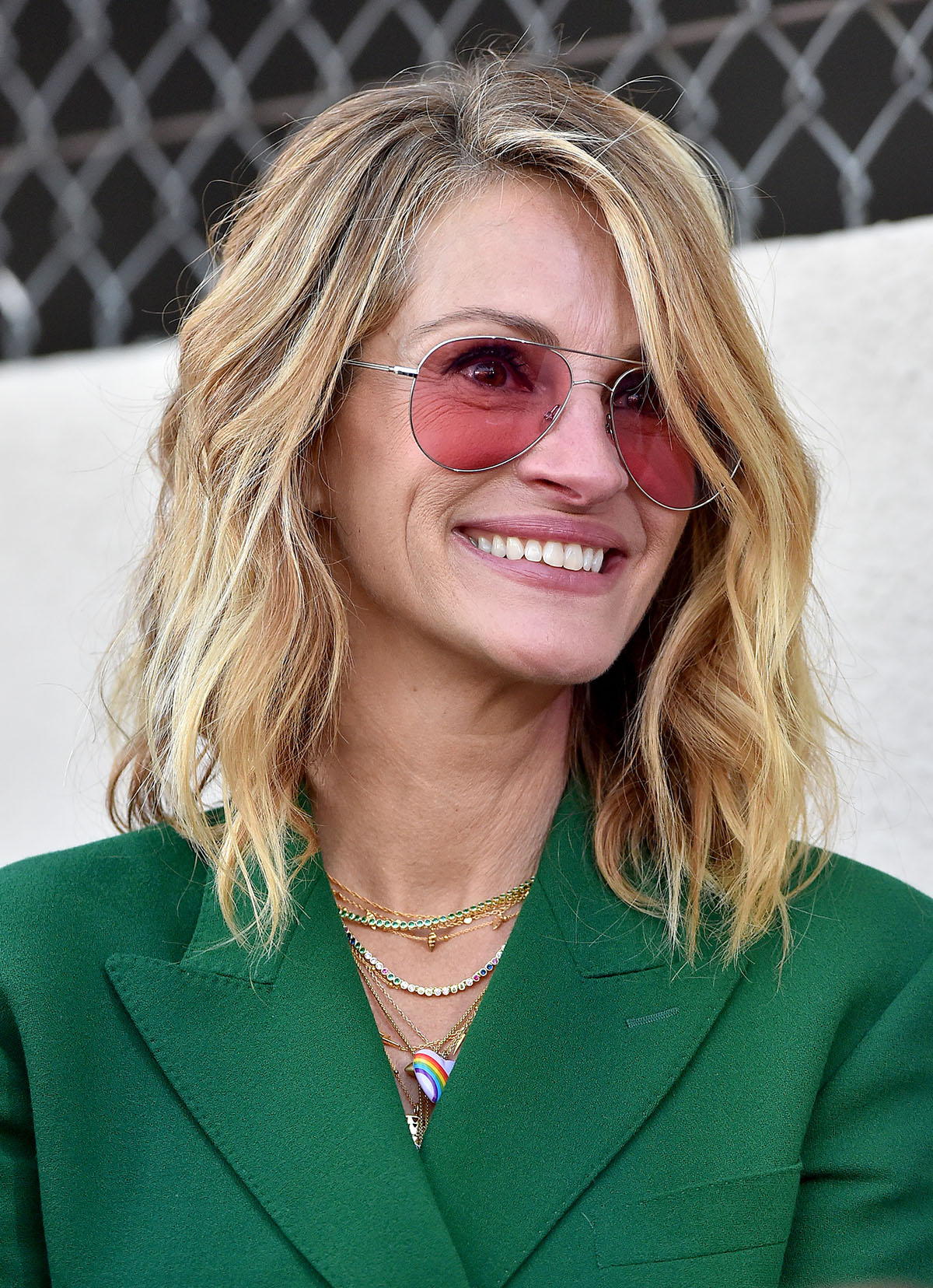 Julia Roberts w okularach przeciwsłonecznych i w zielonej marynarce.