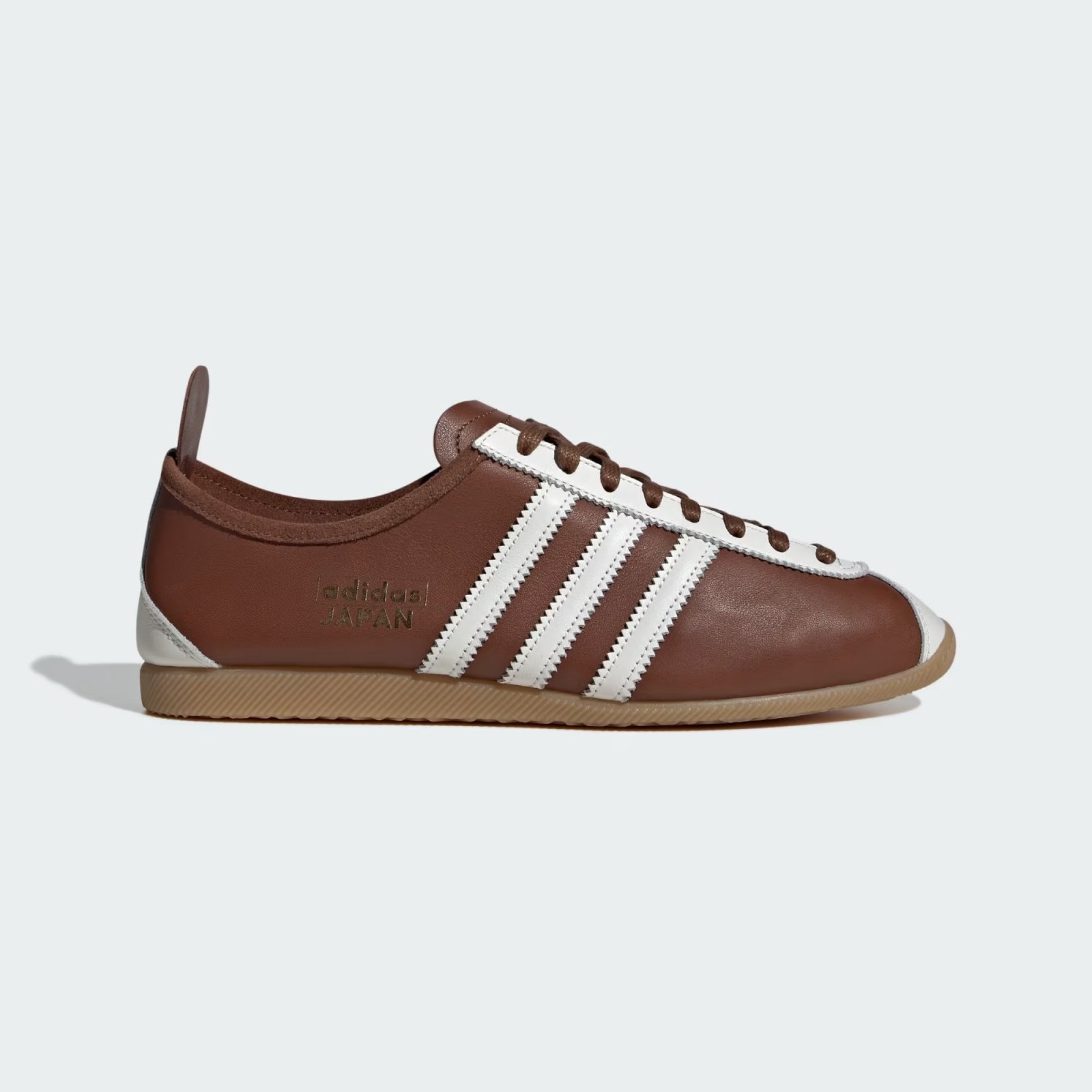 Brązowe sneakersy adidas Japan z białymi trzema paskami i gumową podeszwą.