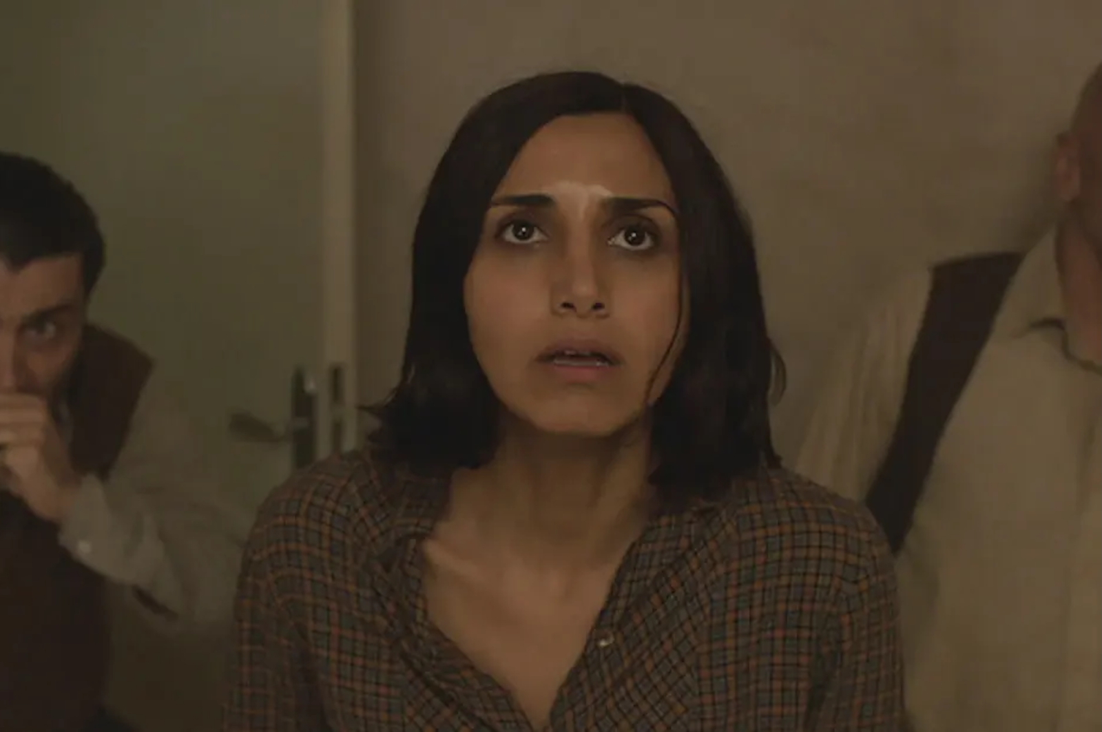 Kadr z filmu „Under the Shadow”, przedstawiający zaniepokojoną kobietę i dwóch mężczyzn w napiętej sytuacji.