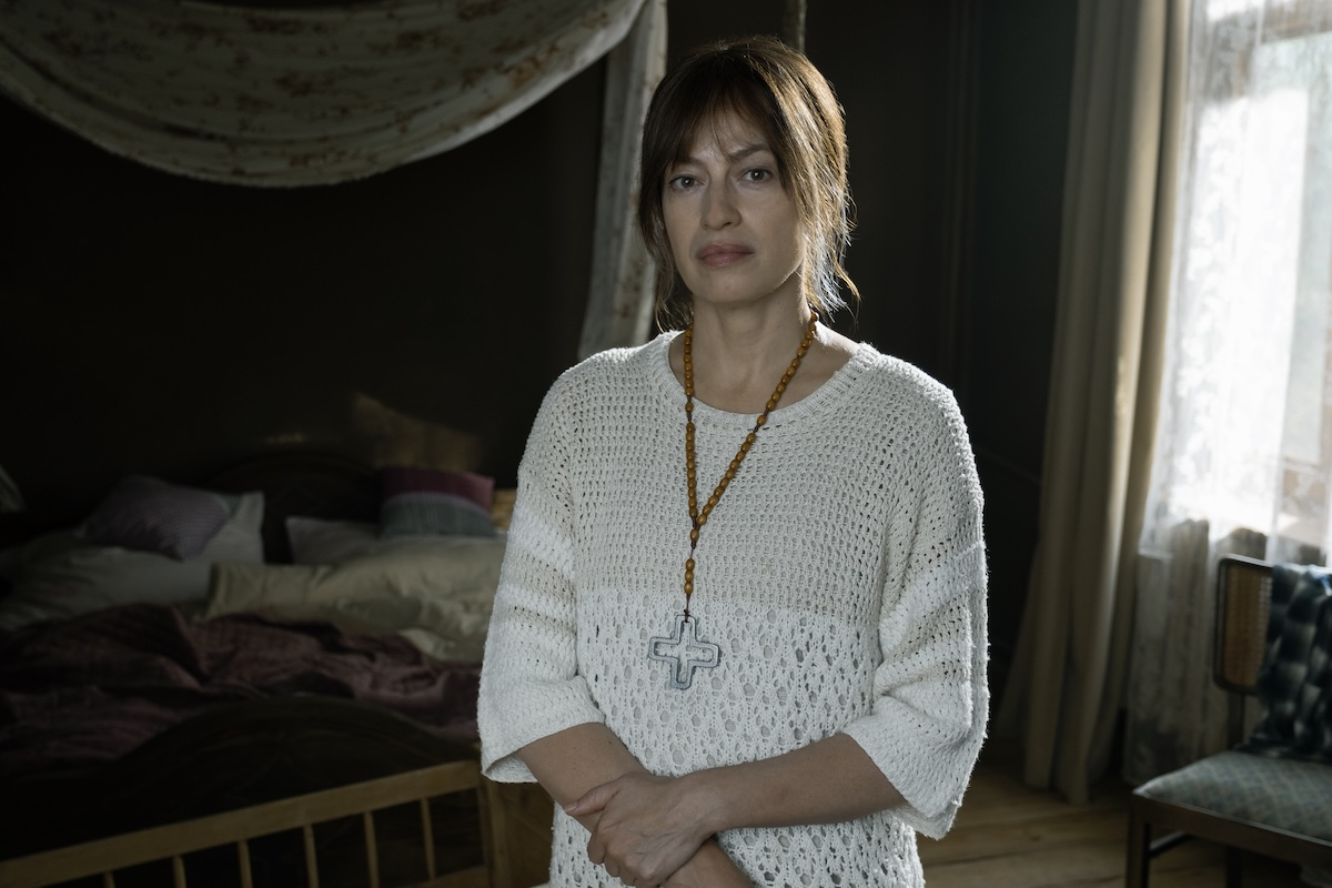 Magdalena Różczka w polskim serialu Max „Niebo. Rok w piekle”, stoi w pokoju z widokiem na łóżko i okno.