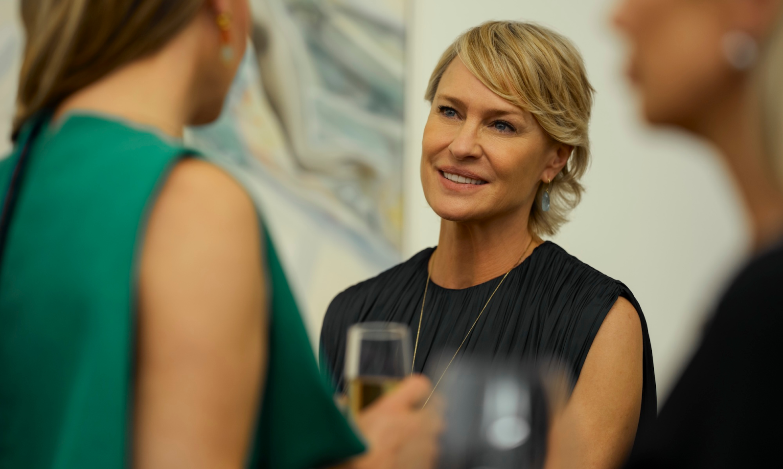 Robin Wright w rozmowie na przyjęciu, promując serial Prime Video „Ta dziewczyna”. W tle inni goście.