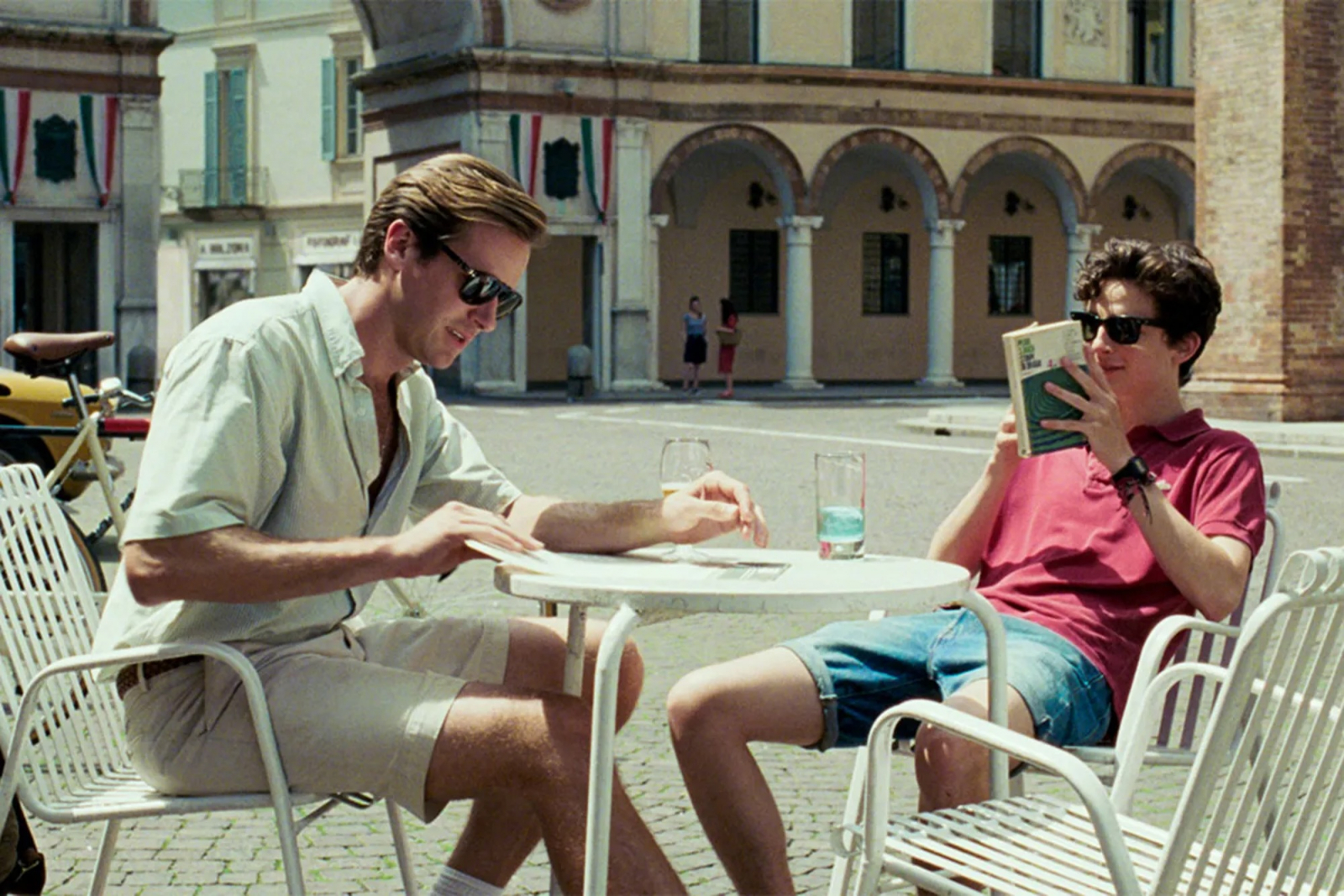 Armie Hammer i Timothée Chalamet w filmie „Tamte dni, tamte noce” siedzą przy stoliku, ciesząc się letnim dniem.