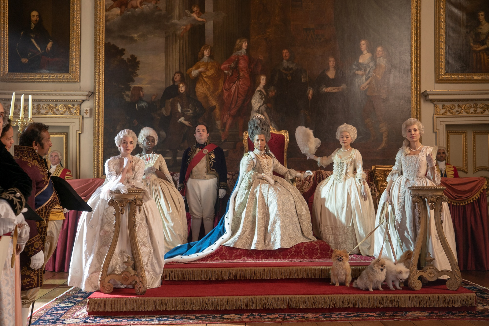 Scena z serialu Netflix „Bridgertonowie”, przedstawiająca postacie w eleganckich, historycznych strojach w pałacowym wnętrzu.