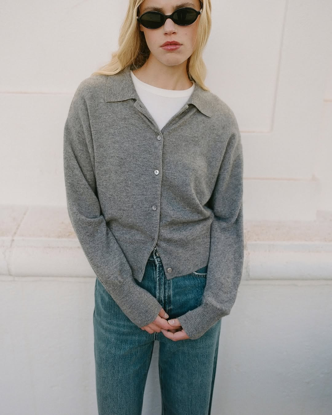 Damski kardigan marki Almada Label w szarym kolorze, noszony z białą koszulką i jeansami. Stylowy look.