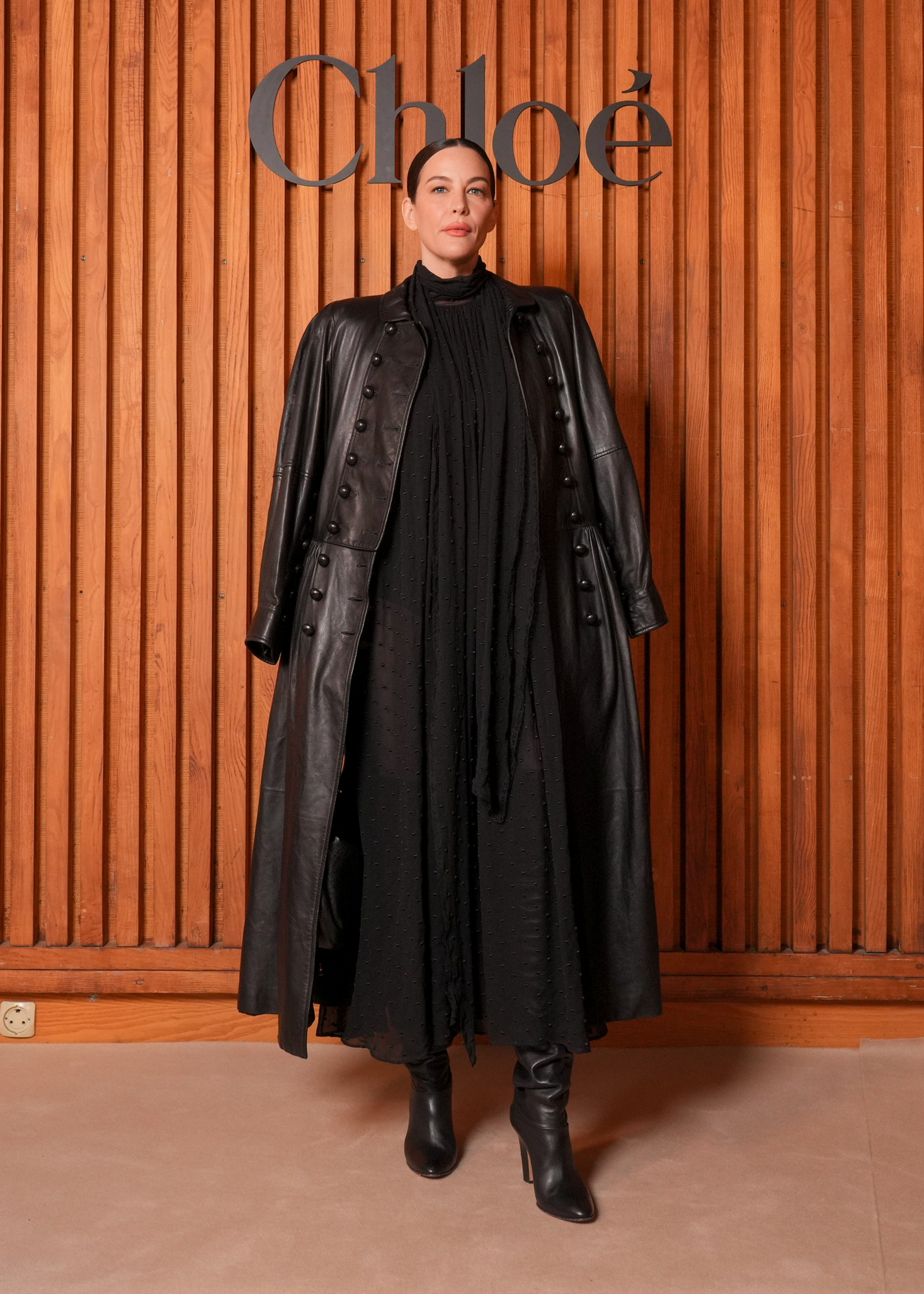 Liv Tyler w maxi sukience boho i wysokich kozakach na obcasie, na pokazie Chloé sezon wiosna-lato 2026.