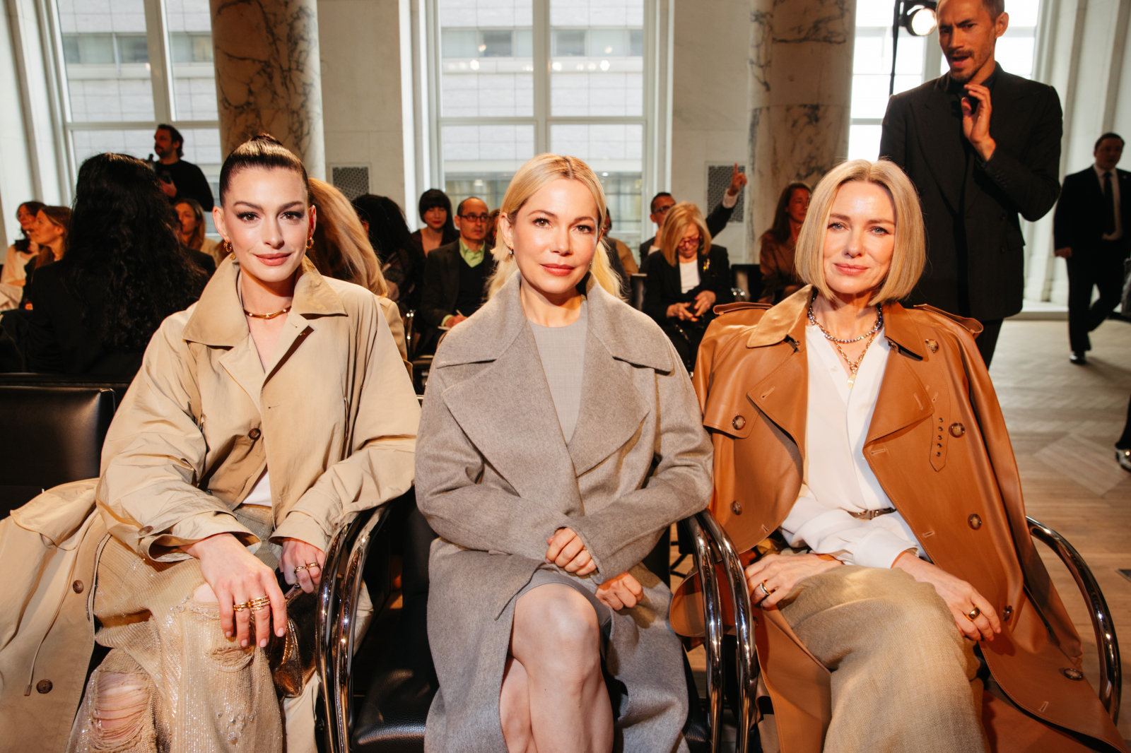 Na pokazie Ralph Lauren siedzą Anne Hathaway, Michelle Williams i Naomi Watts w eleganckich płaszczach.