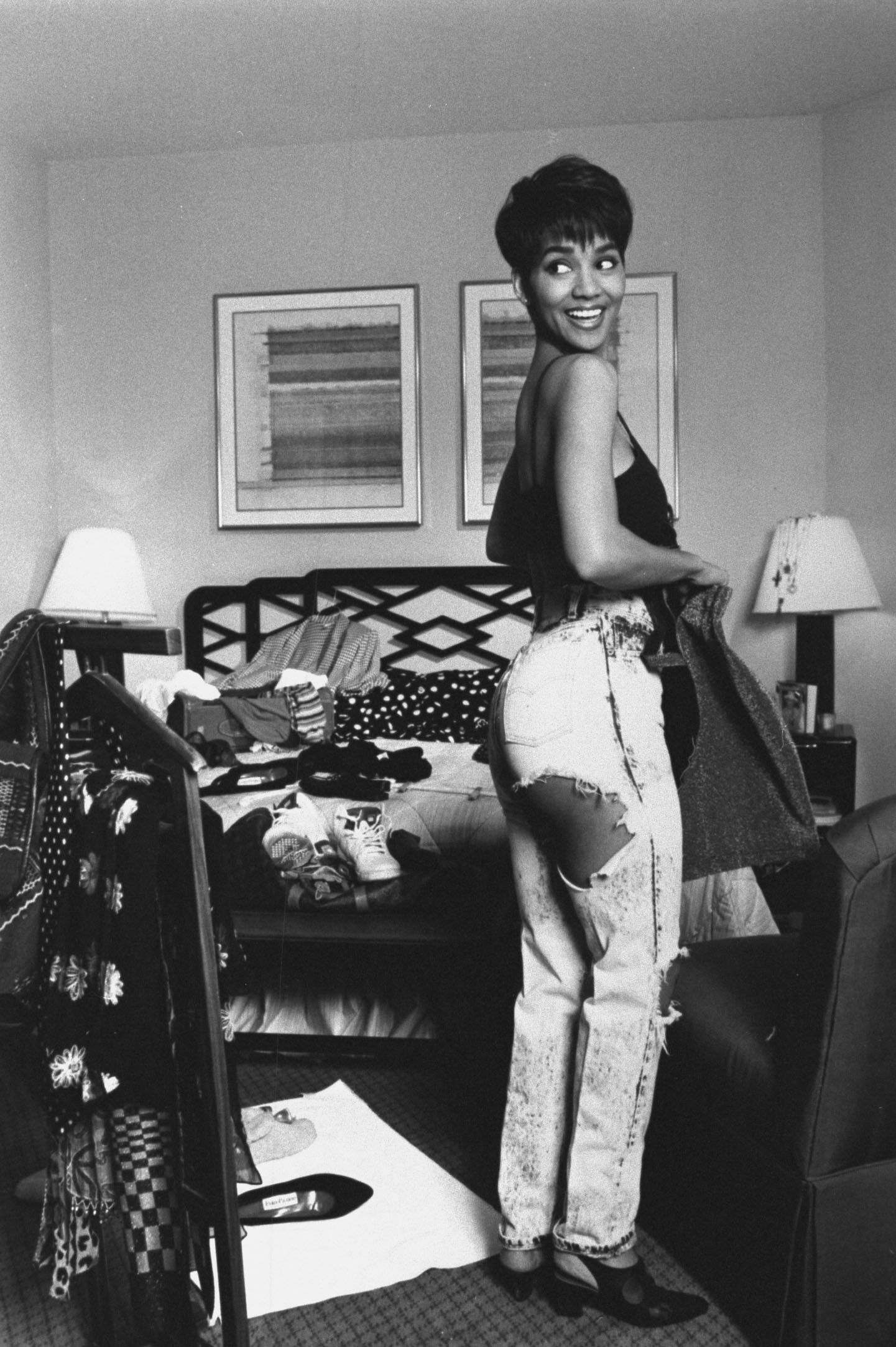 Młoda Halle Berry, 1992 rok, w pokoju hotelowym, uśmiechnięta, w modnych, przetartych dżinsach.