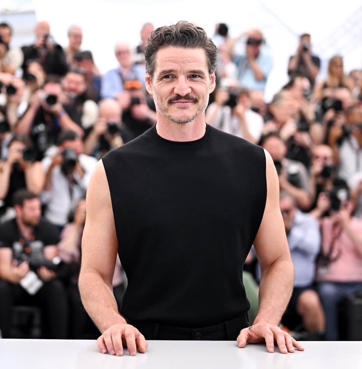 Pedro Pascal na festiwalu Cannes 2025, pozując na tle licznych fotografów.