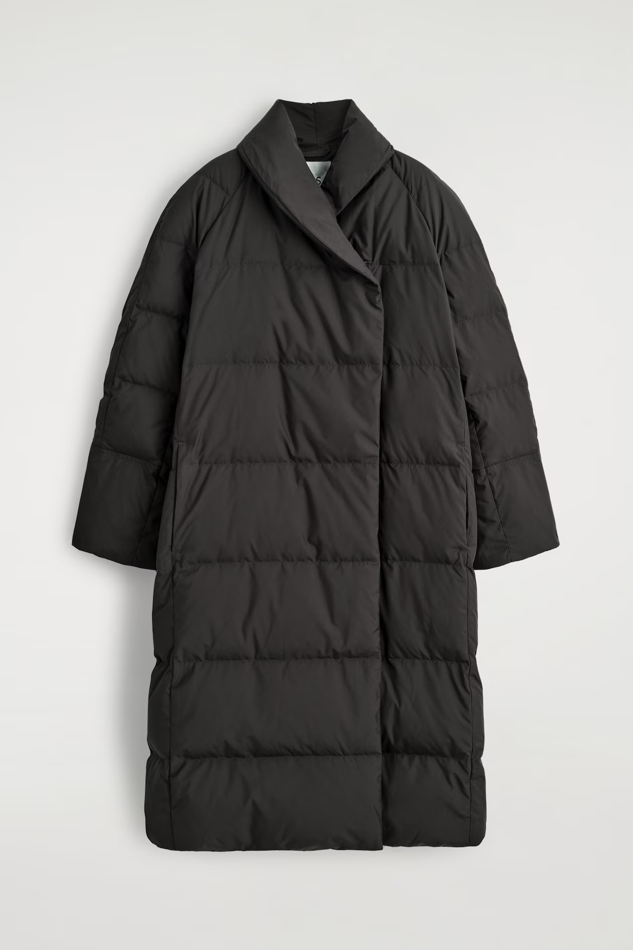 Czarna długa kurtka puchowa damska marki COS, o oversize&#039;owym kroju i prostym wzorze.