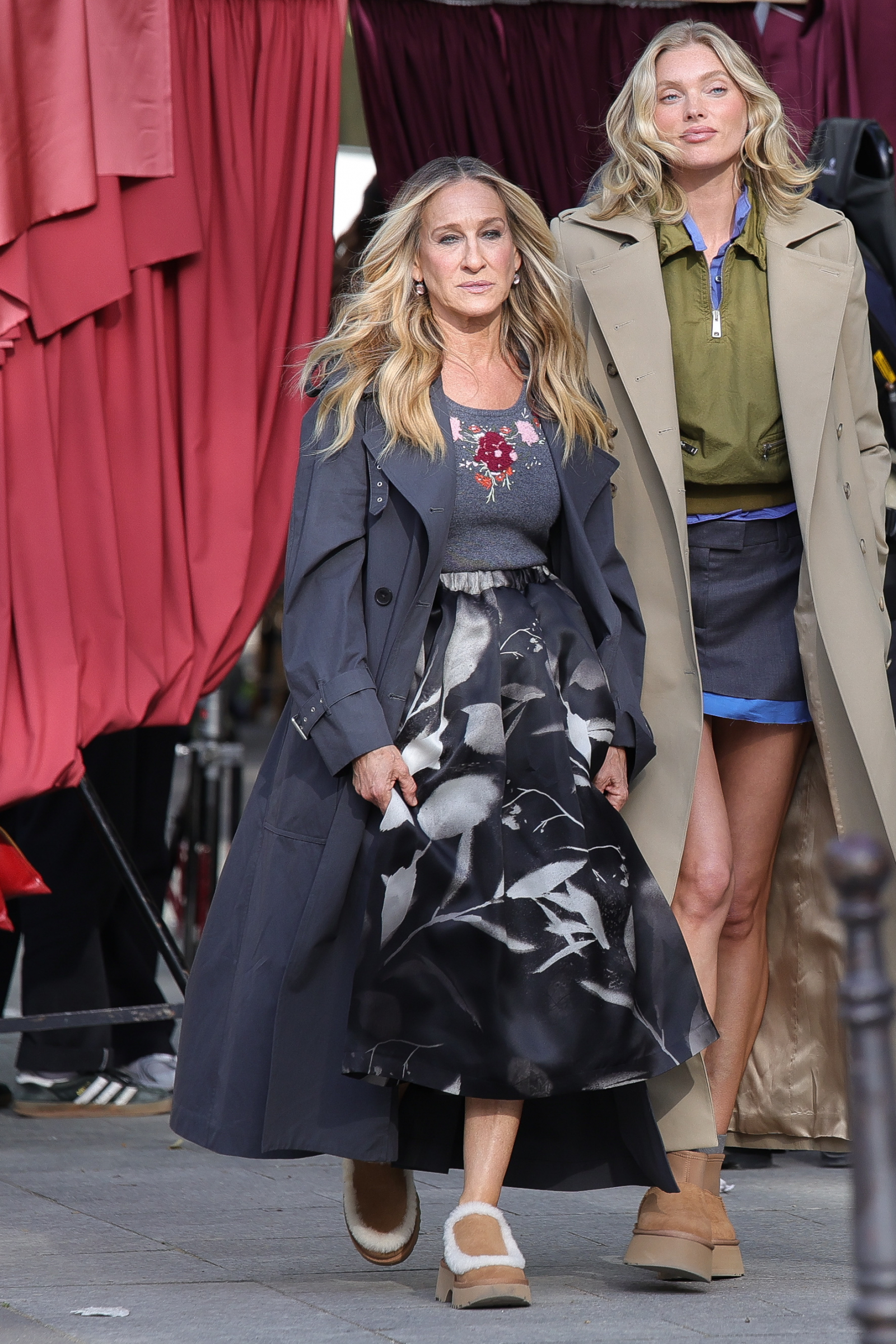 Sarah Jessica Parker i Elsa Hosk na chodniku, obie w modnych stylizacjach z butami Ugg.